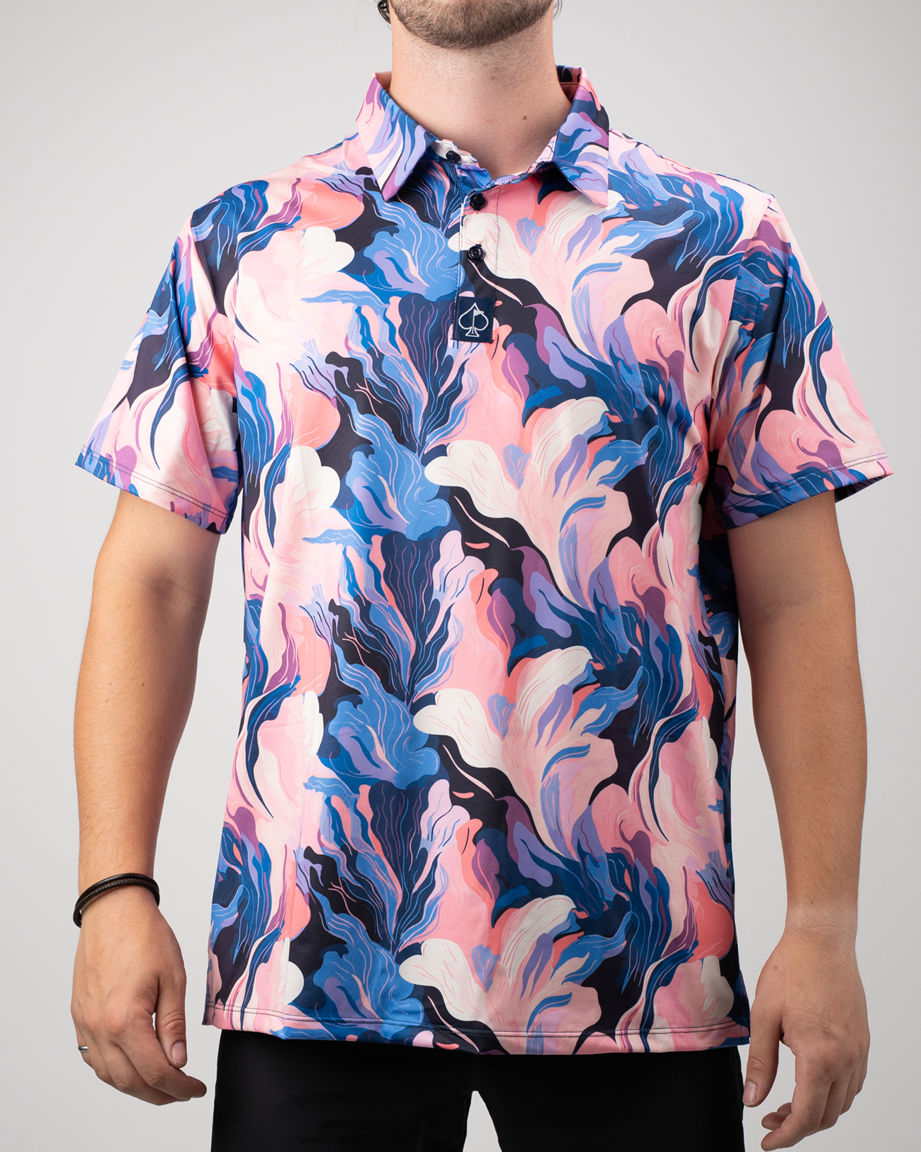 Bold golf polo featuring a melting floral pattern in vibrant pink, blue, and white hues, perfect for standing out on the course.