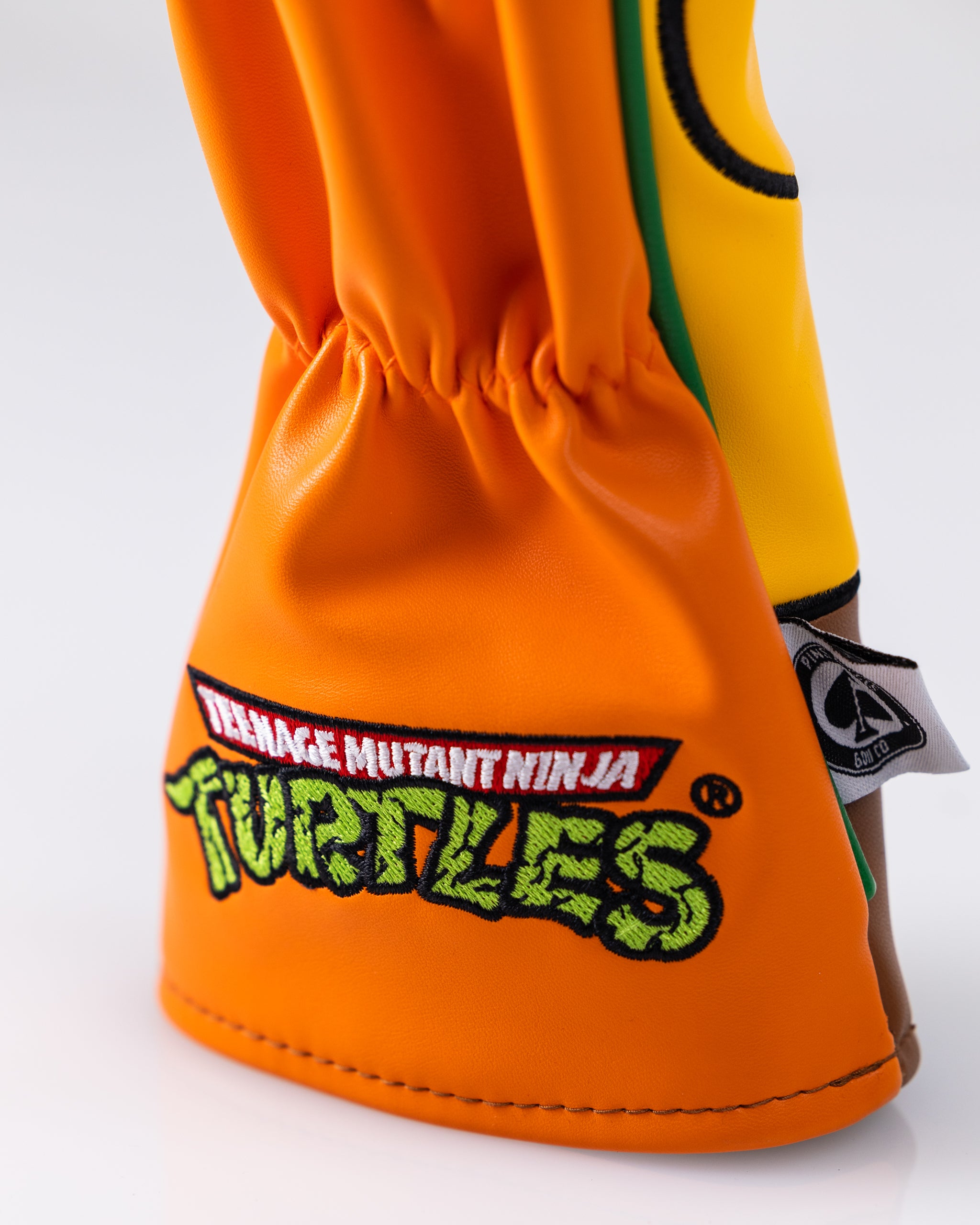 TMNT Michelangelo Fairway Cover featuring a vibrant orange and green design with the character's face and a turtle shell pattern.