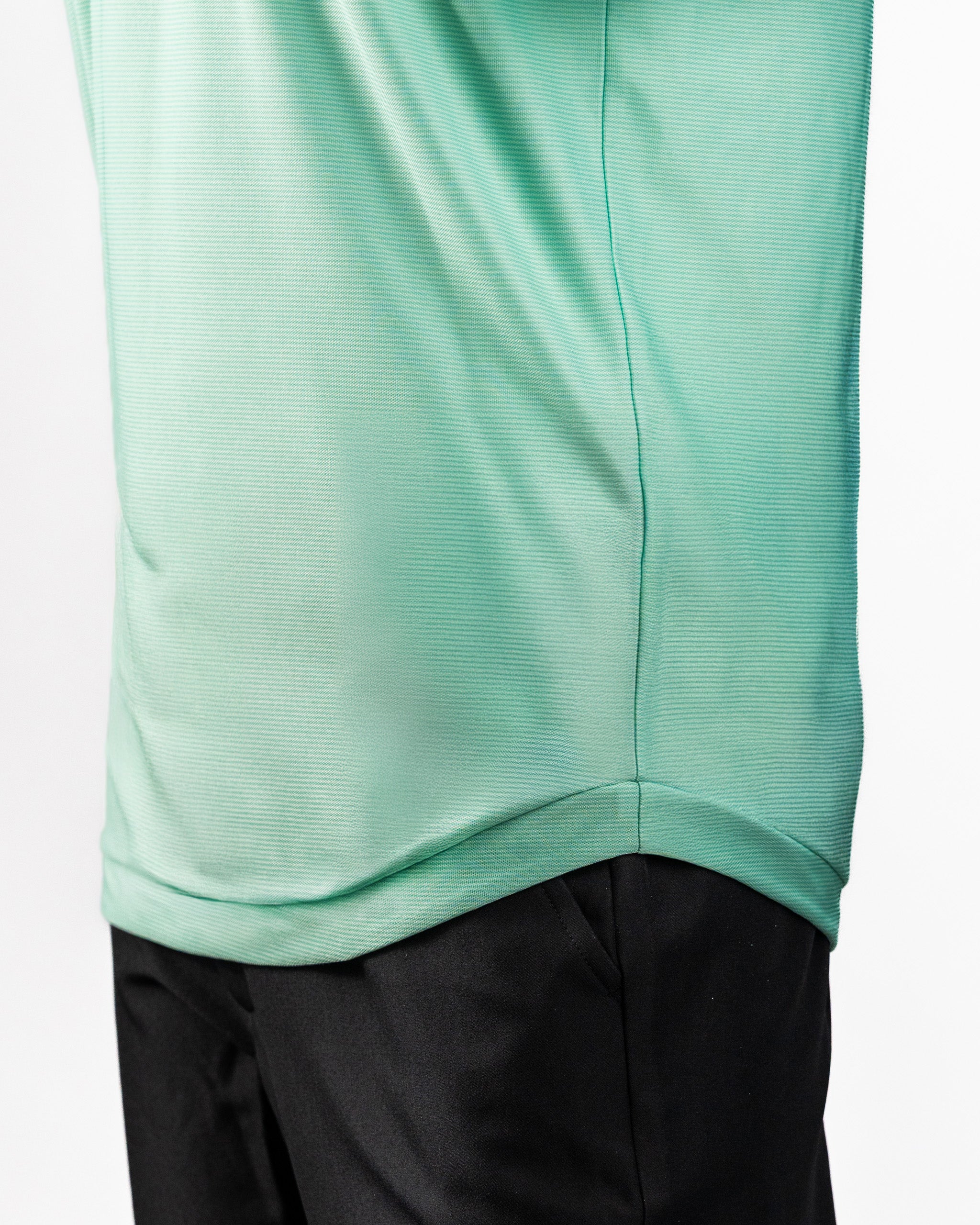 Close-up of a mint green Player Preferred™ Polo with spearmint stripes, paired with black pants.