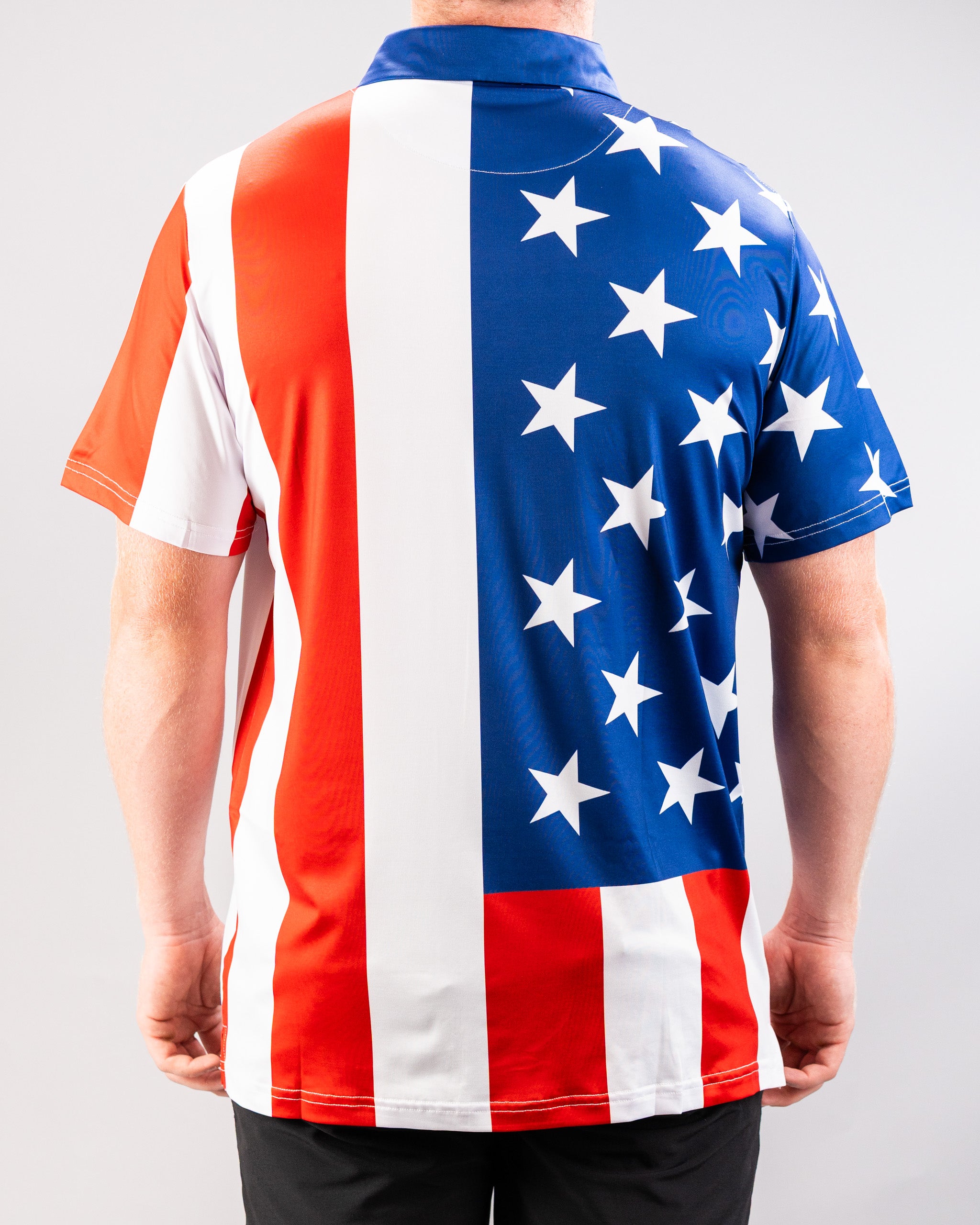 A person wearing a short-sleeved shirt featuring a design inspired by the American flag, with red and white stripes and a blue field with white stars.