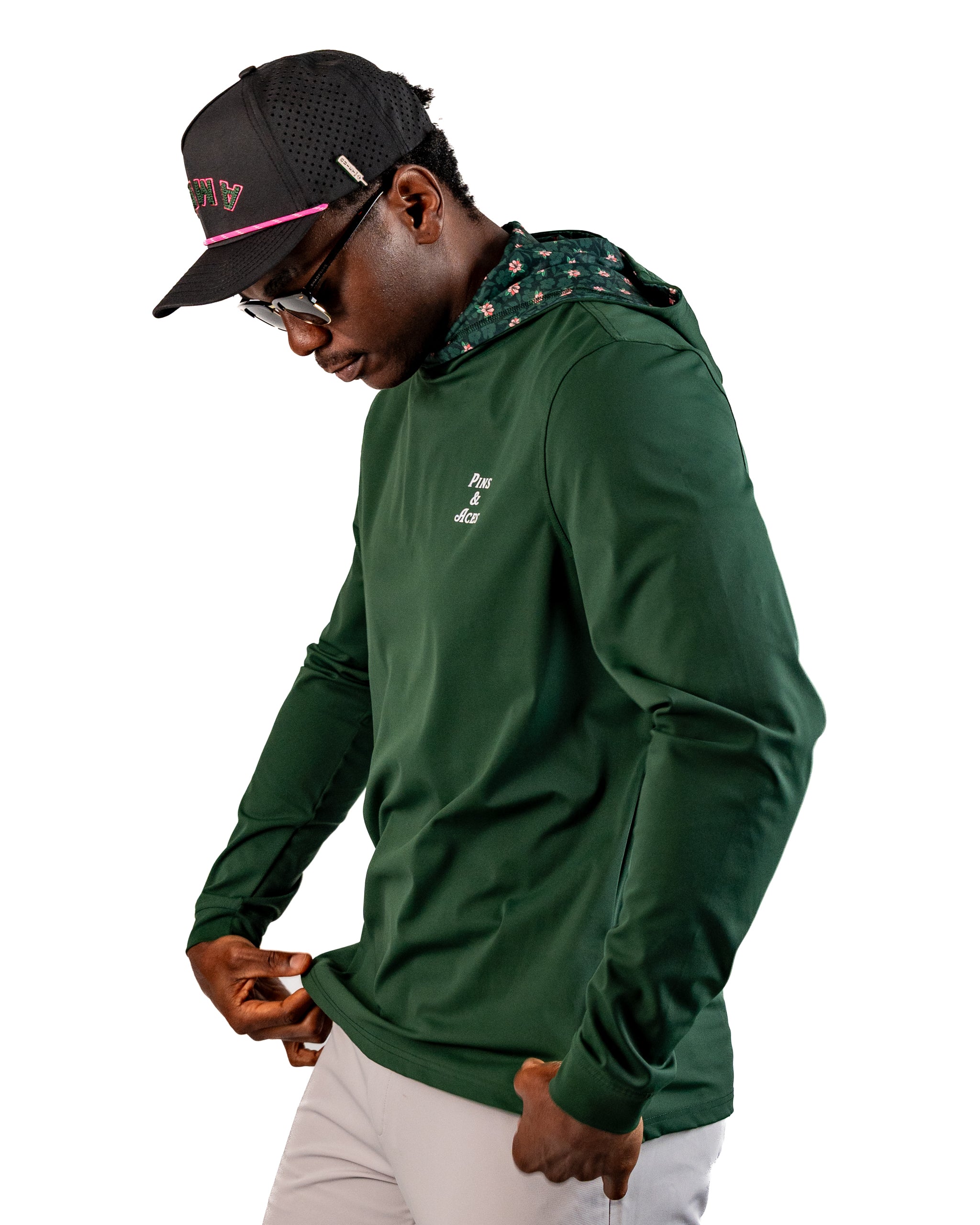 Man wearing a dark azalea performance golf hoodie with a patterned hood, showcasing a stylish and functional design.