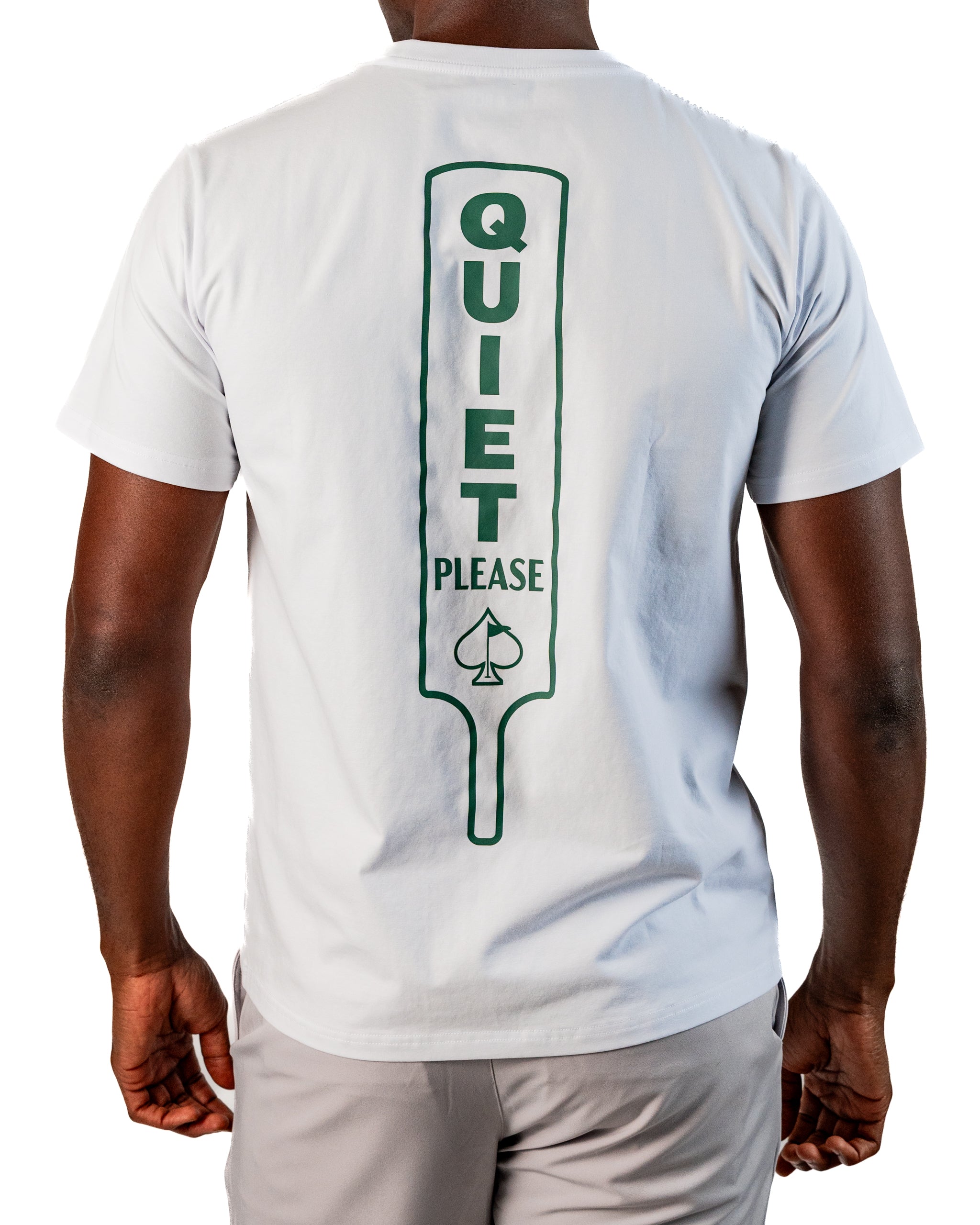 White tee shirt featuring a large green "QUIET PLEASE" graphic on the back, designed for golfers seeking a stylish statement.