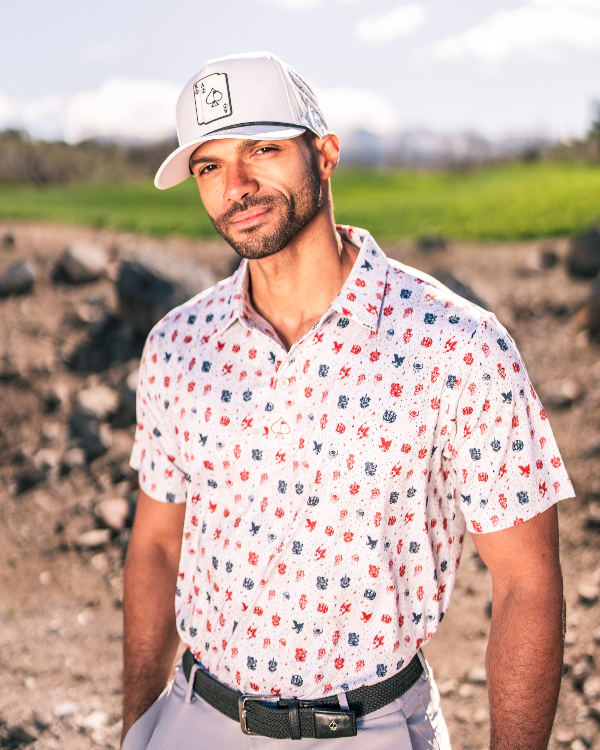 Stylish golfer wearing an American Traditional polo shirt with a playful pattern and a matching cap on a sunny course.