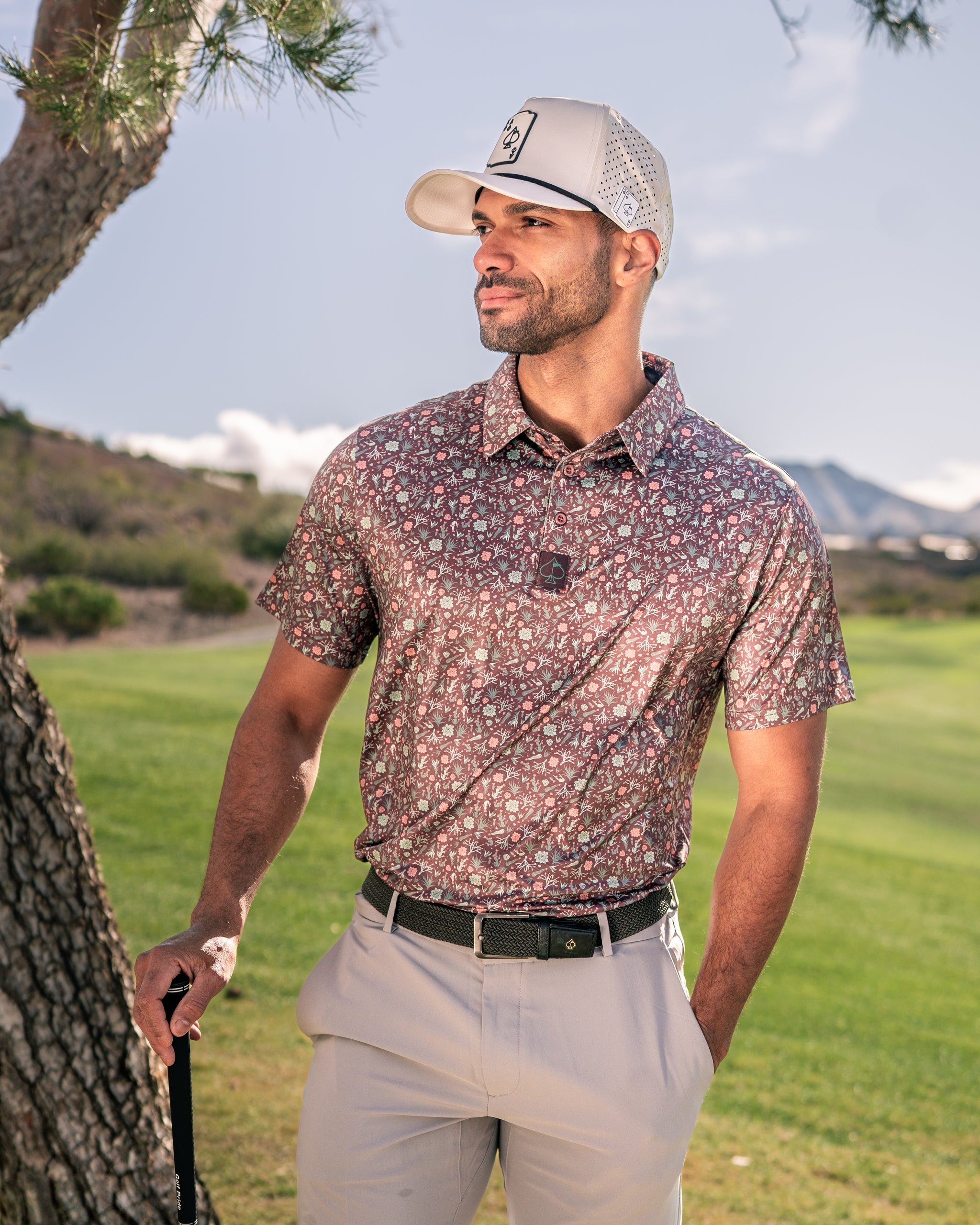 Stylish golfer wearing a Desert Sage floral polo shirt on the course, showcasing bold patterns and a modern fit.