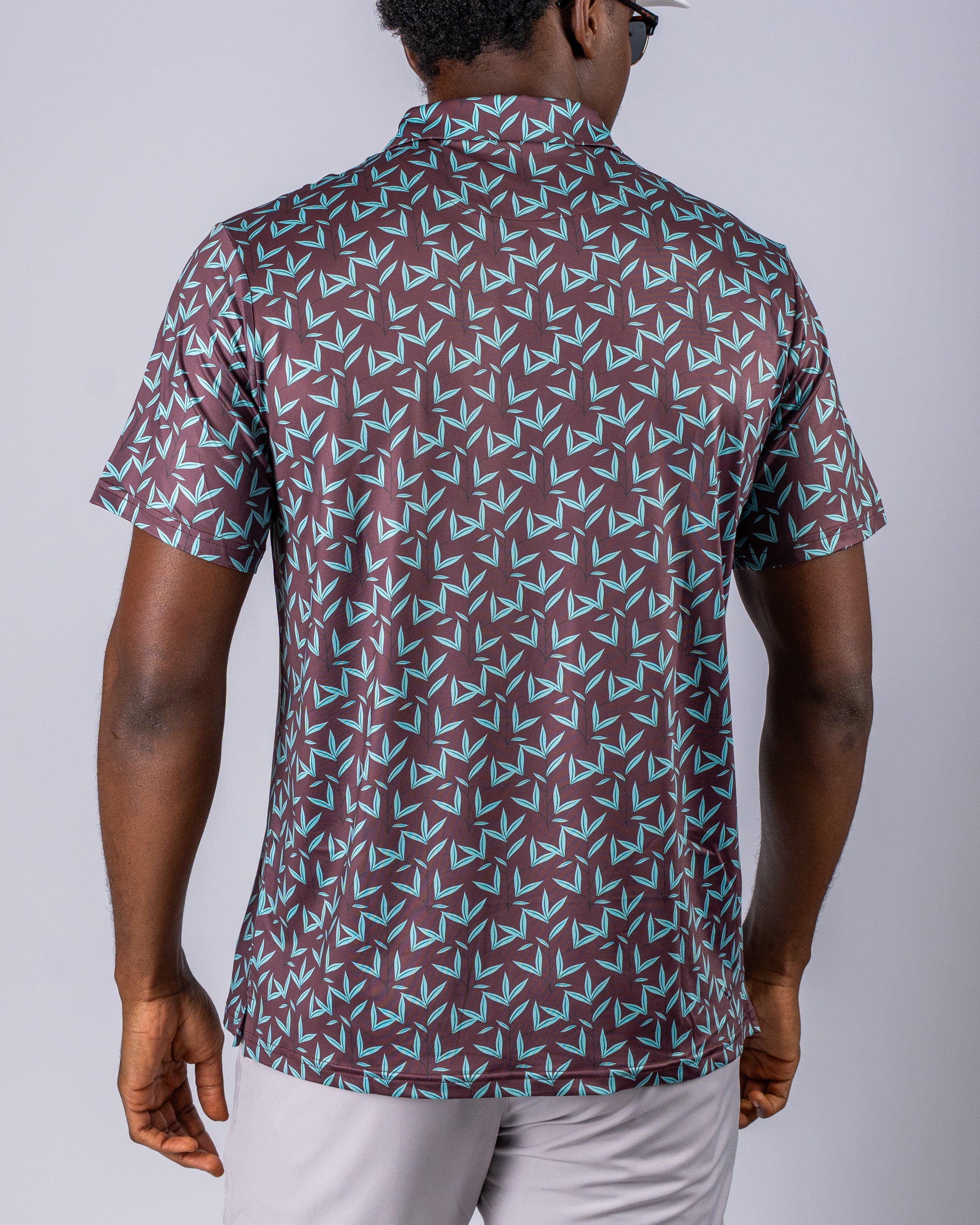 Men's short-sleeve golf shirt in cocoa brown with a geometric teal pattern, designed for a stylish and bold look on the course.