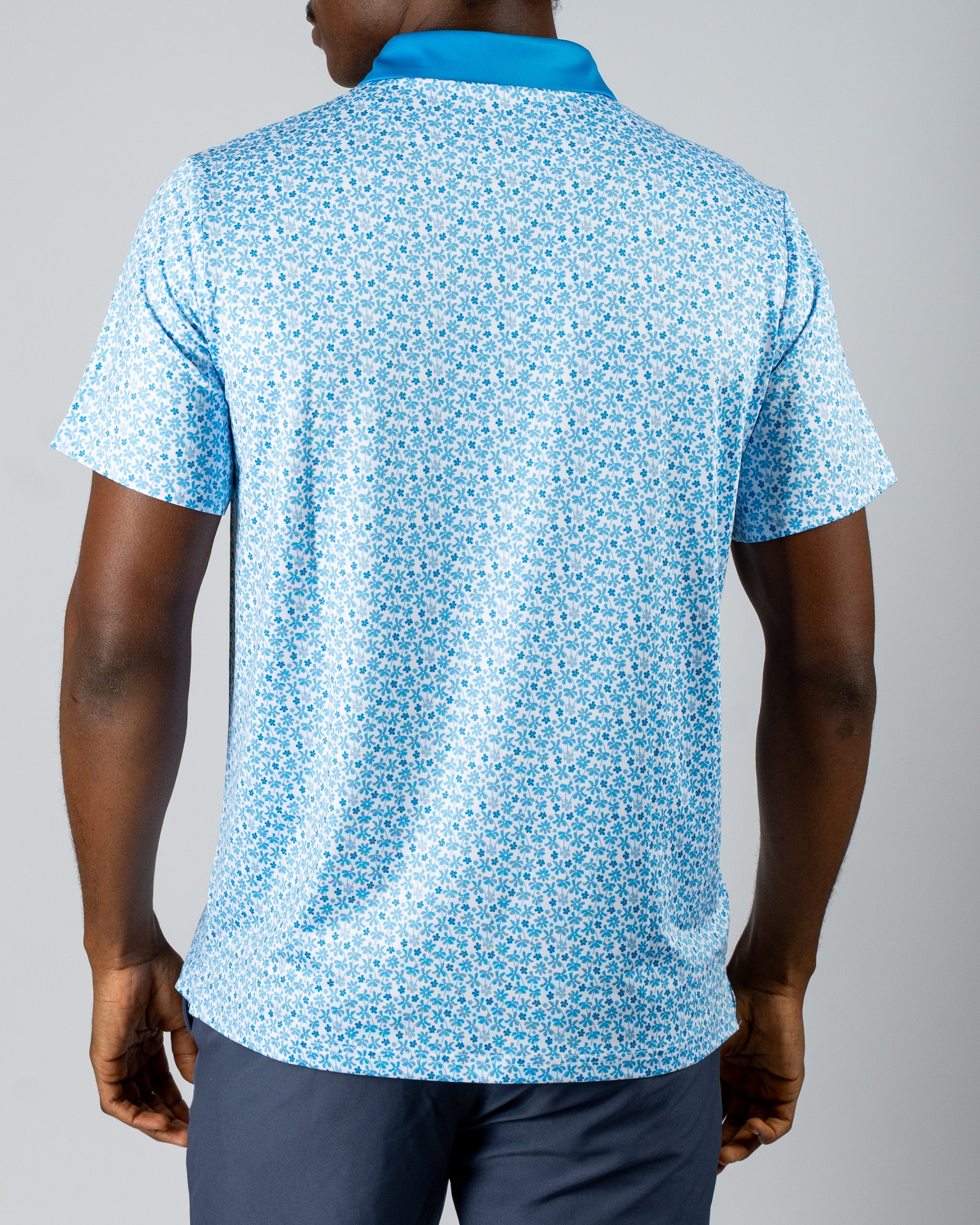 Men's blue golf polo shirt featuring a vibrant floral pattern, designed for comfort and style on the course.