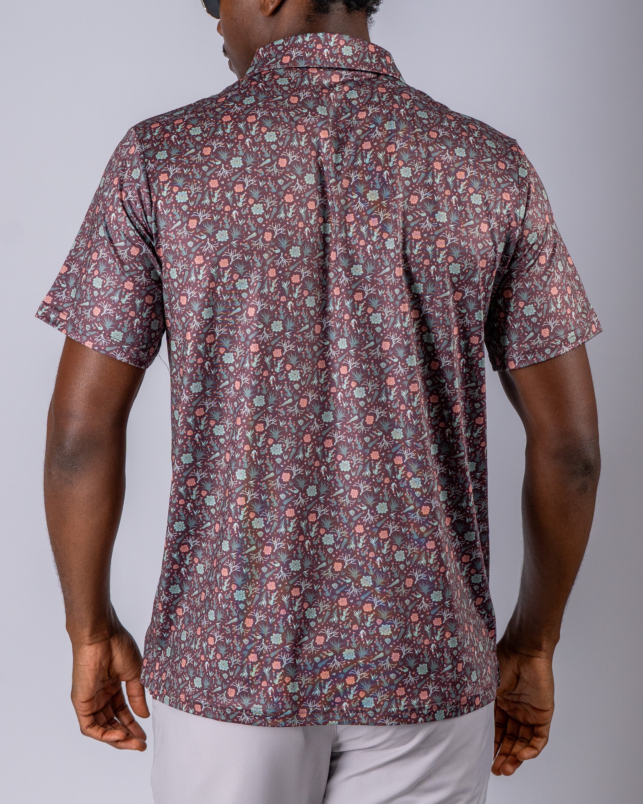 Men's short-sleeve golf shirt in Desert Sage pattern featuring a colorful floral design, perfect for stylish play on the course.