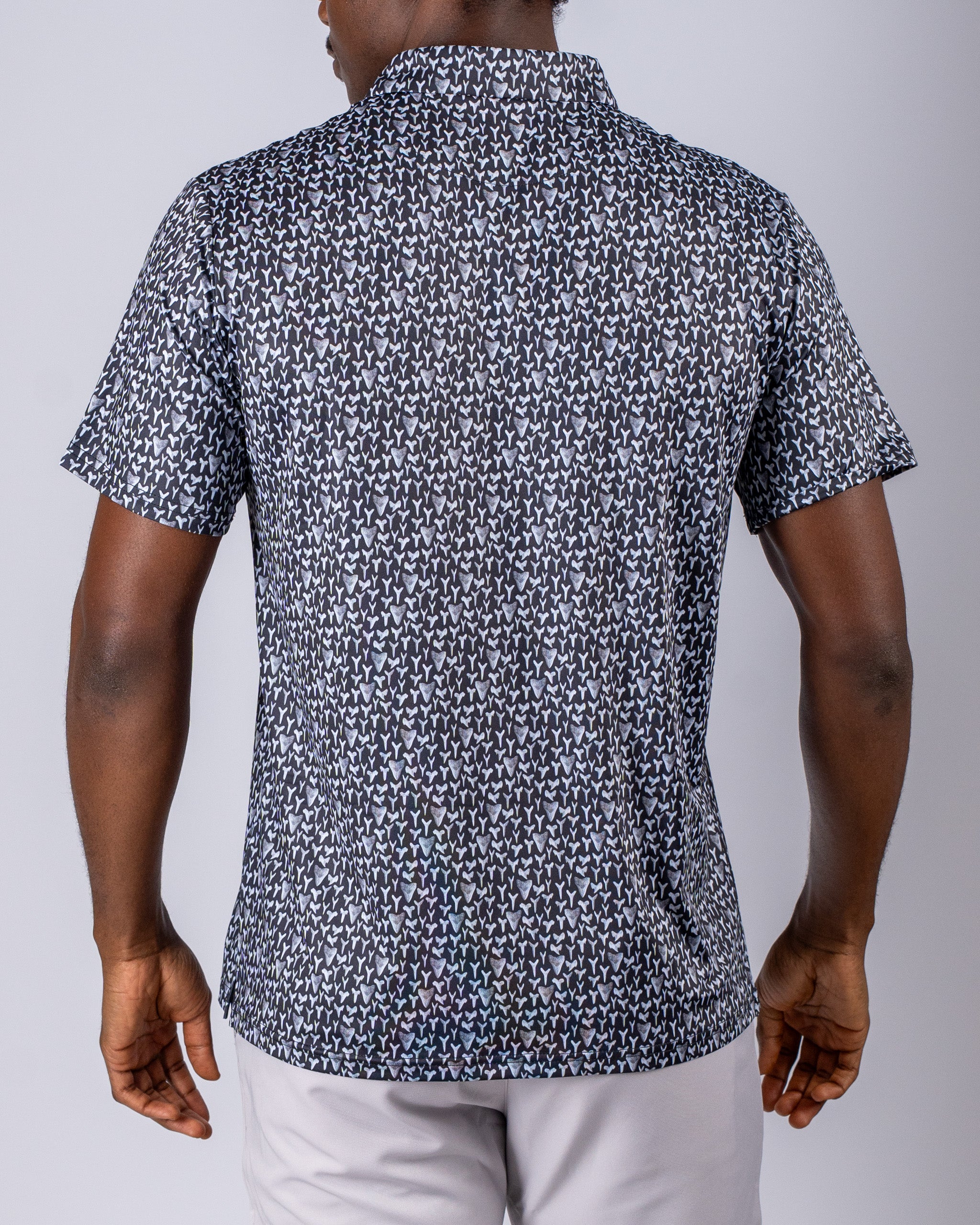 Men's short-sleeve golf shirt featuring a bold shark tooth pattern in black and white, designed for stylish performance on the course.
