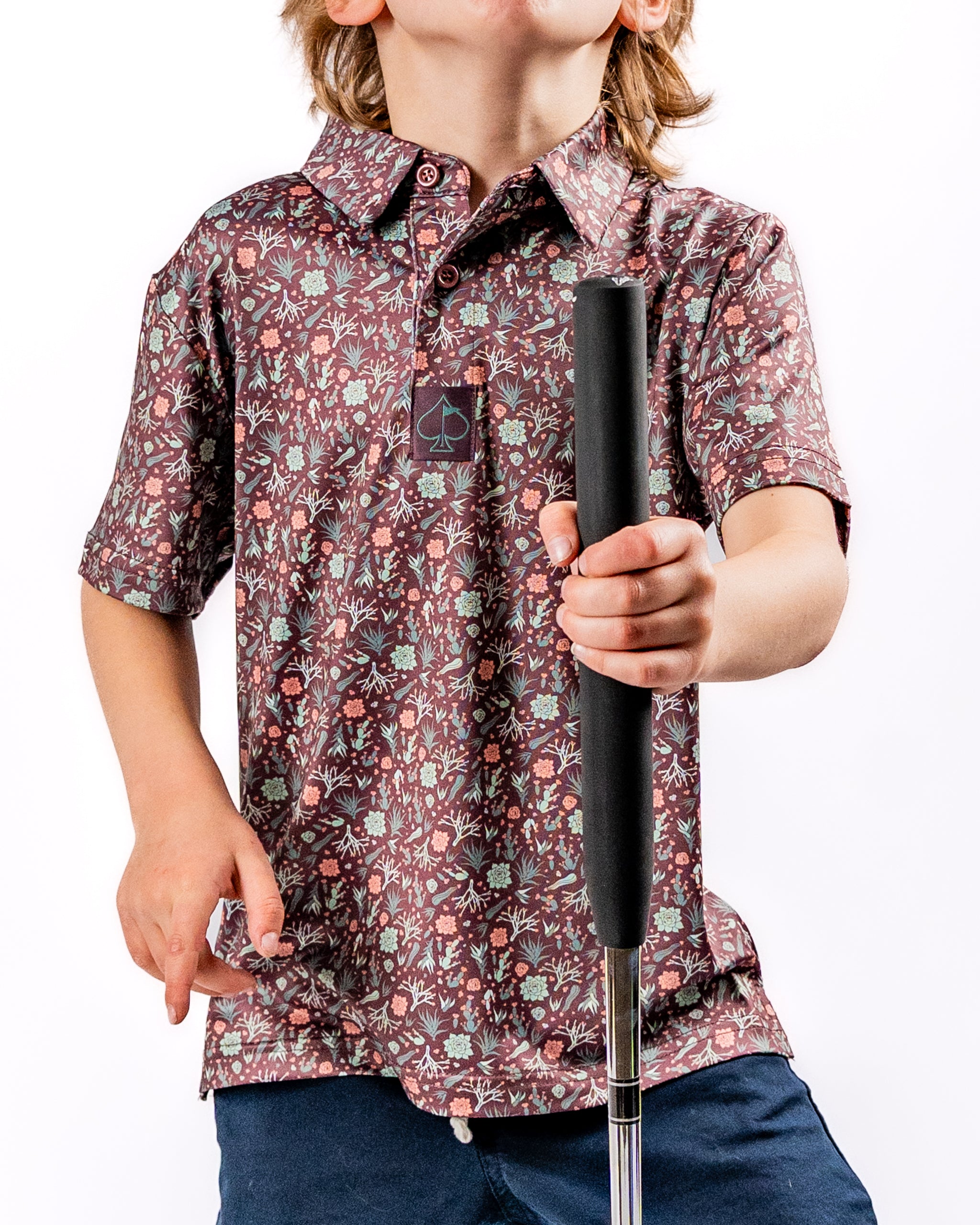 Youth Desert Sage golf shirt featuring a vibrant floral pattern, perfect for young golfers looking to stand out on the course.