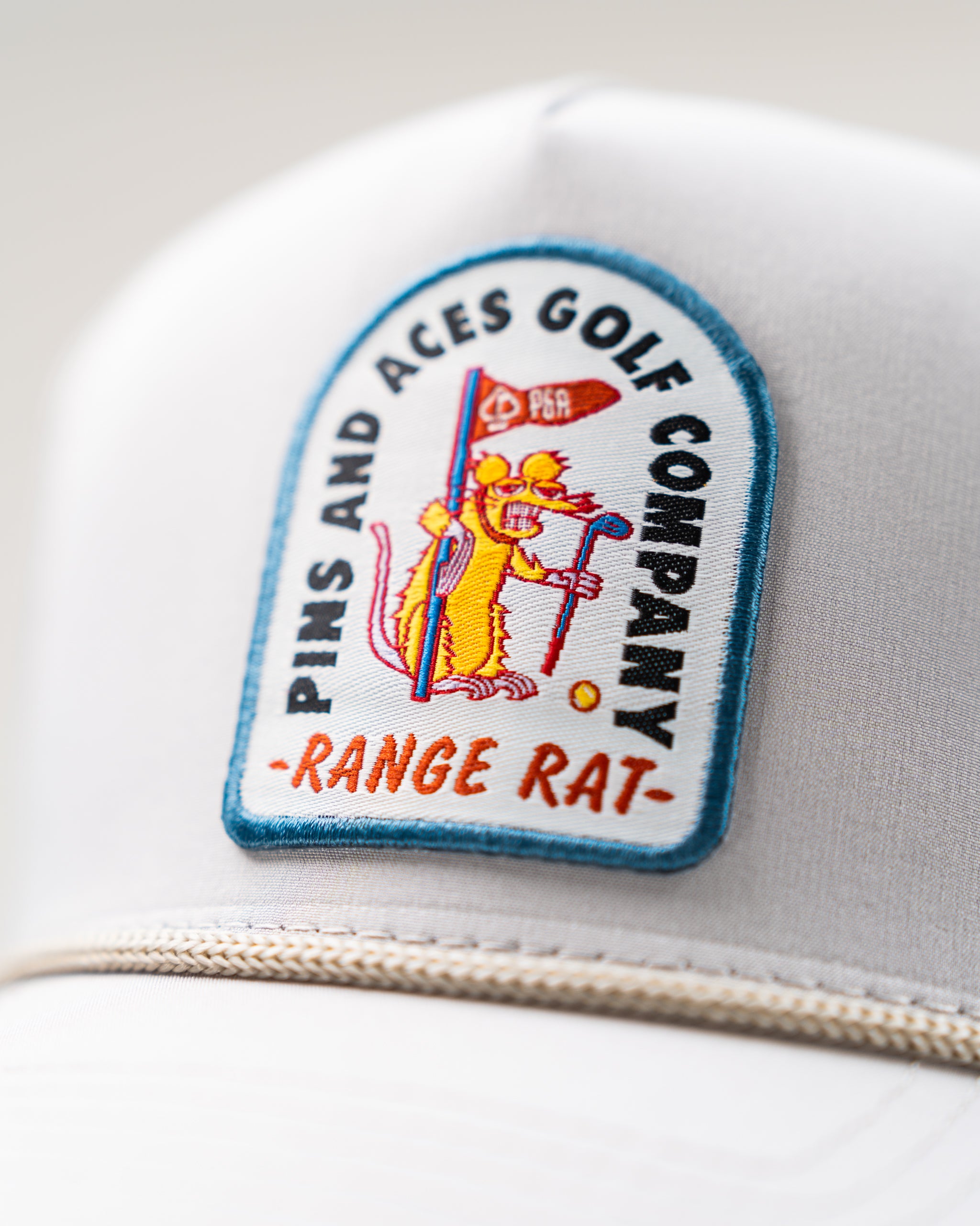 Perforated Rope Hat in Bone color with a Range Rat logo, featuring a stylish design and breathable material.