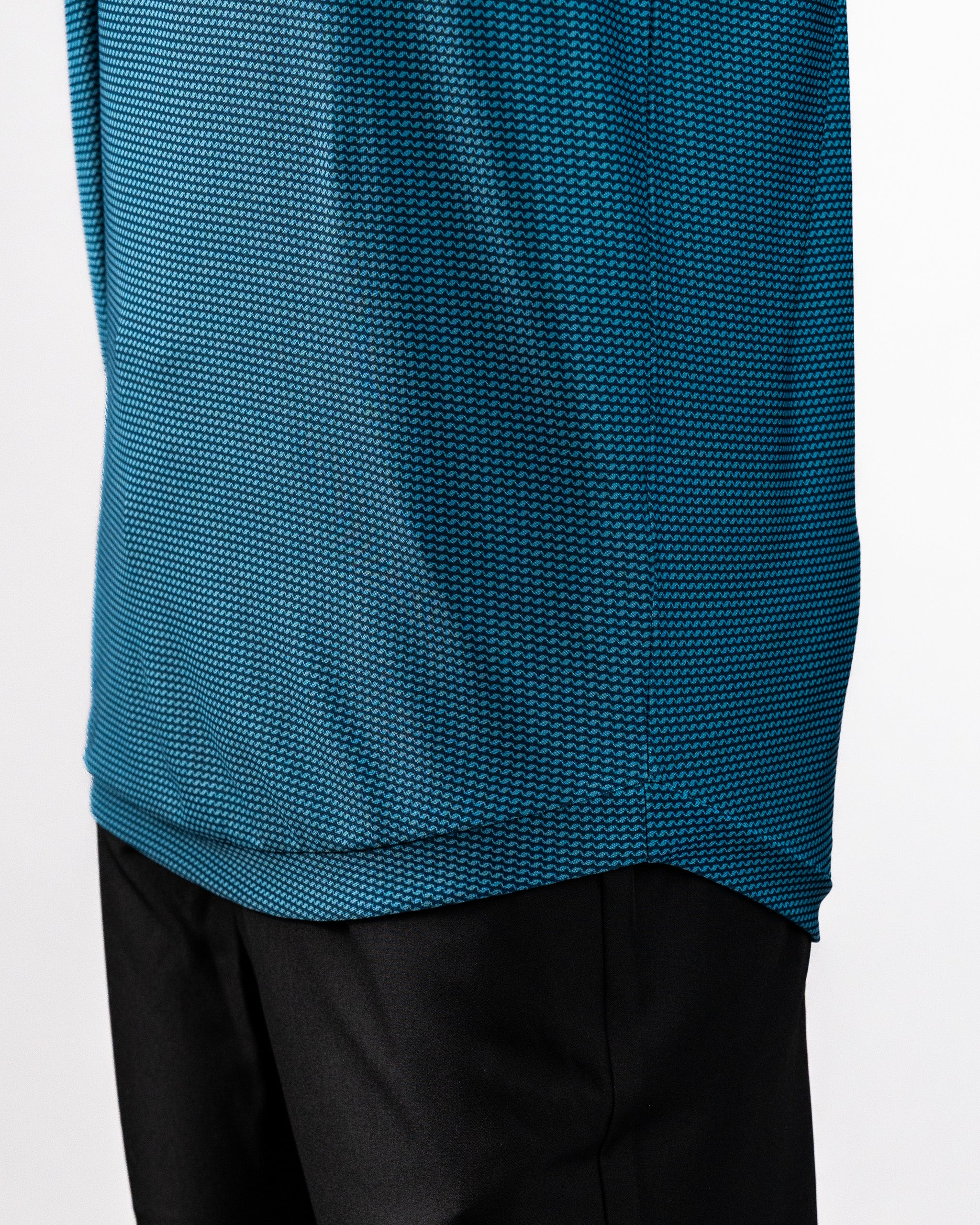Close-up of a blue Player Preferred™ Polo shirt with a wave pattern, paired with black pants.