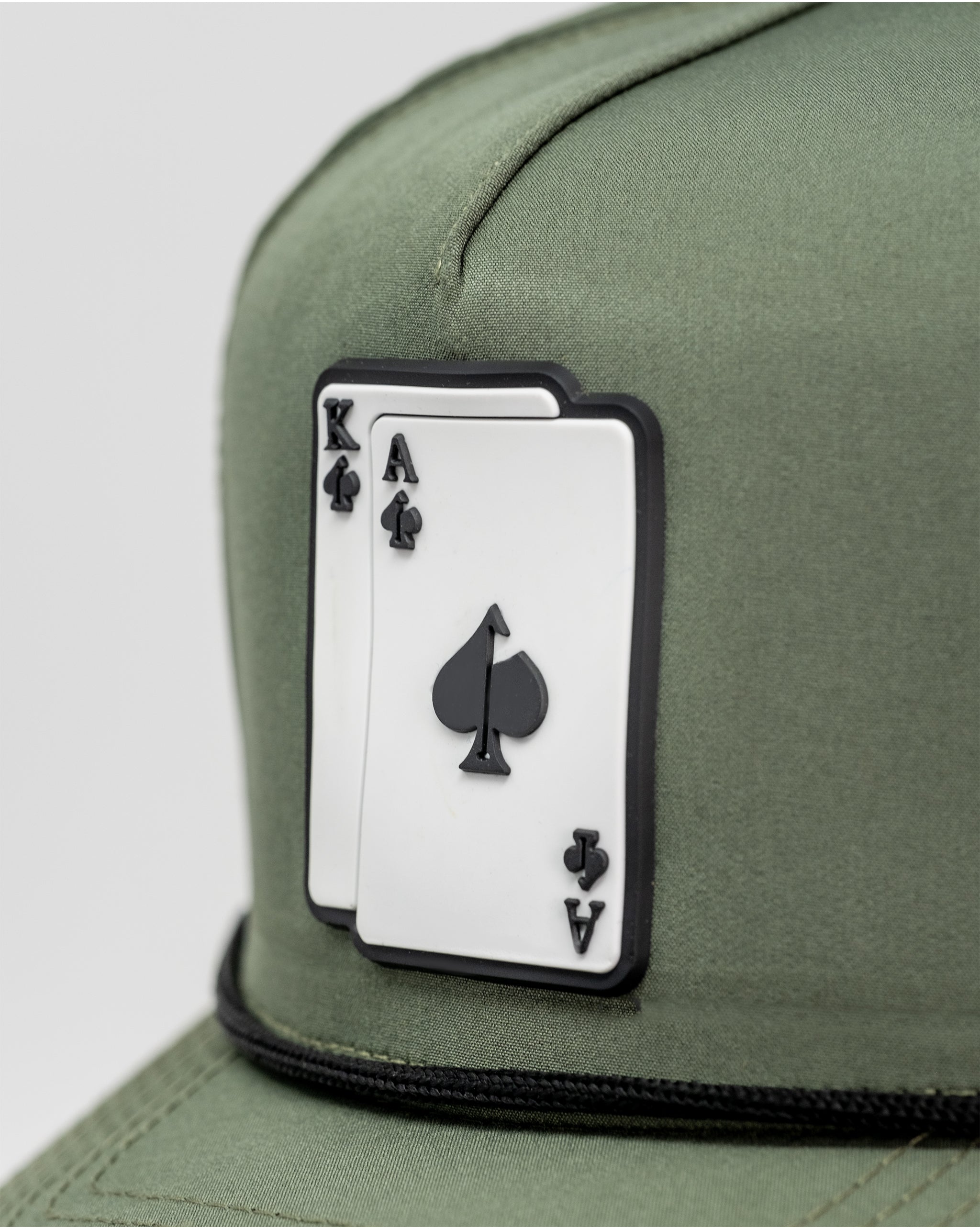 Perforated olive rope hat with an Alaska patch detail.