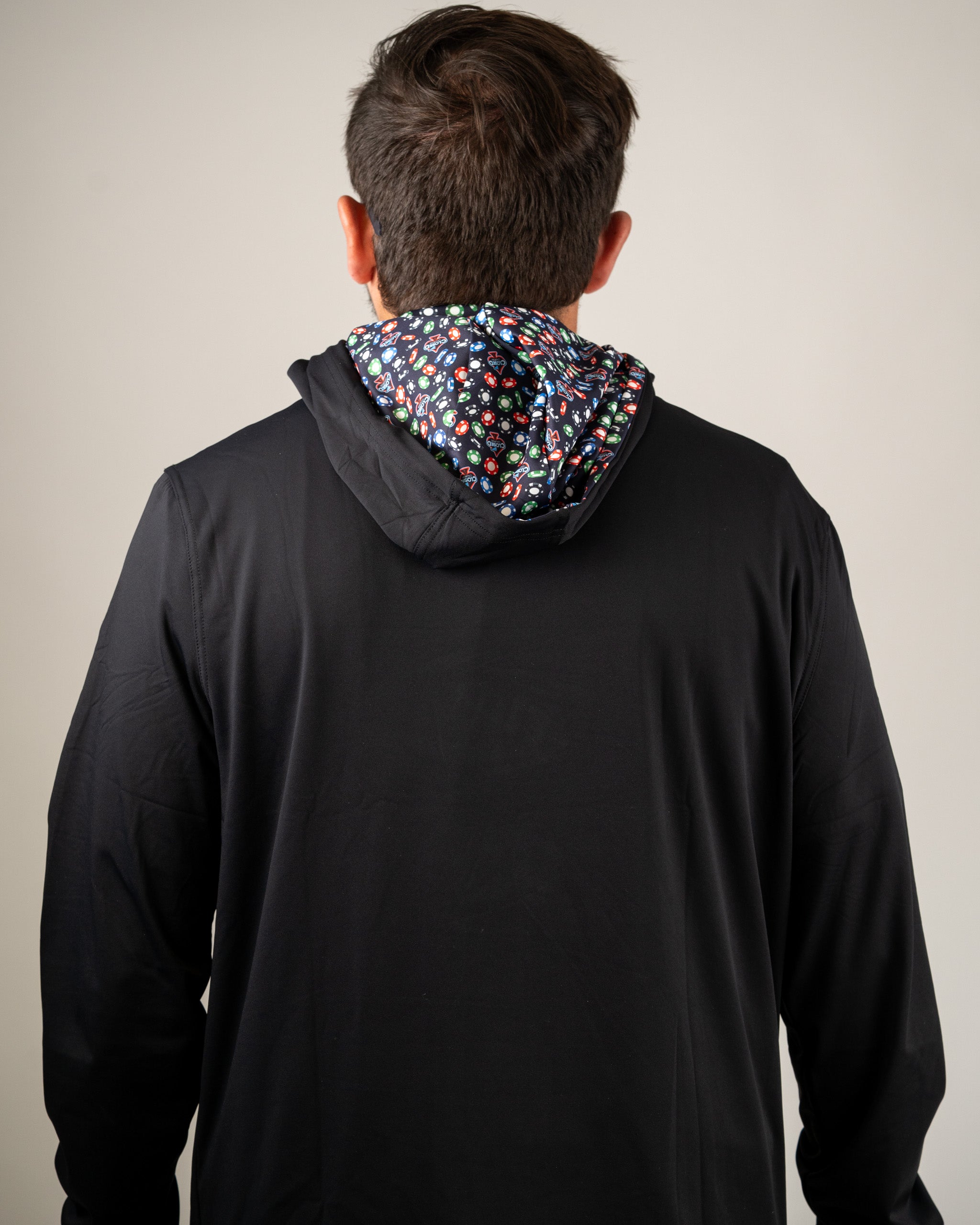 Men's performance golf hoodie in black with a colorful patterned hood, designed for comfort on the course.