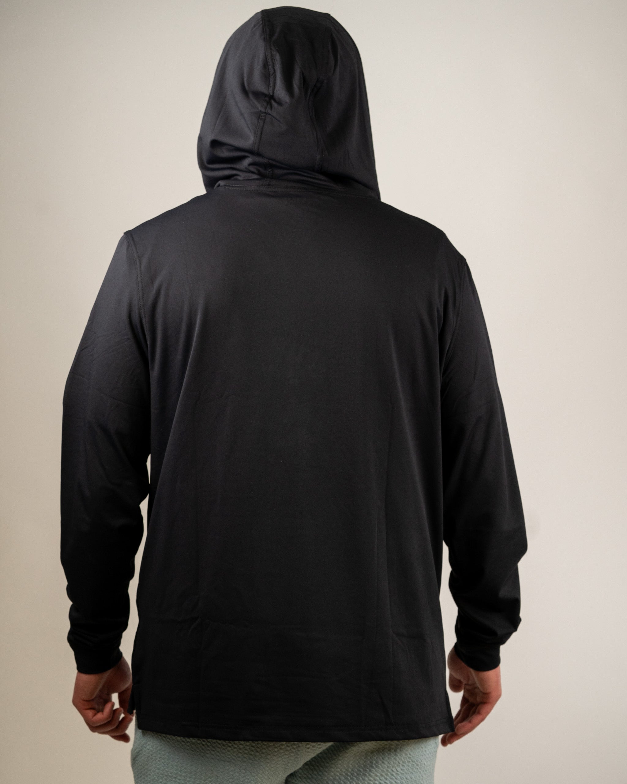 Back view of a black performance golf hoodie, featuring a relaxed fit and a hood, designed for comfort on the course.