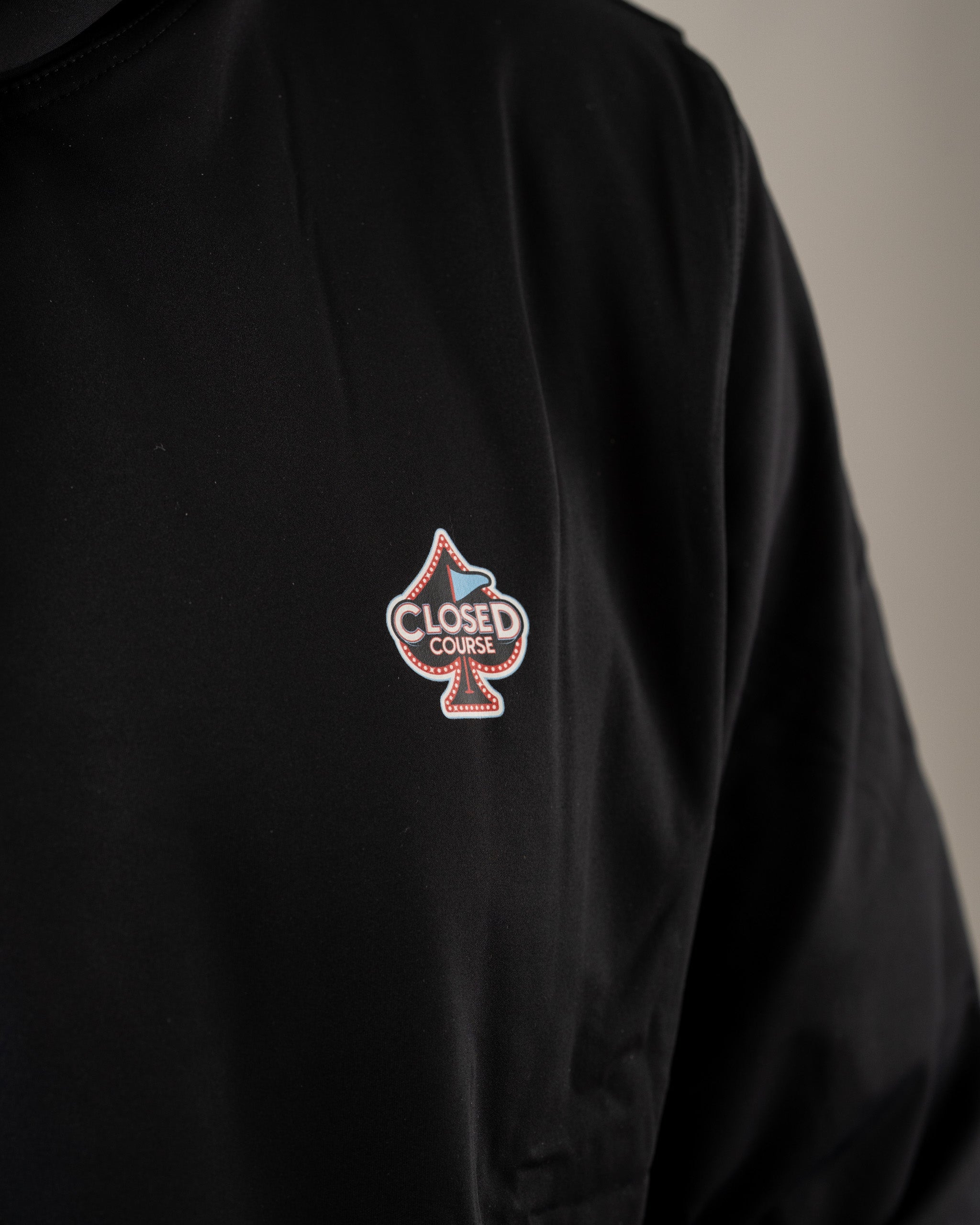 Black performance golf hoodie featuring a stylish "Closed Course" logo on the chest, perfect for on and off the course.