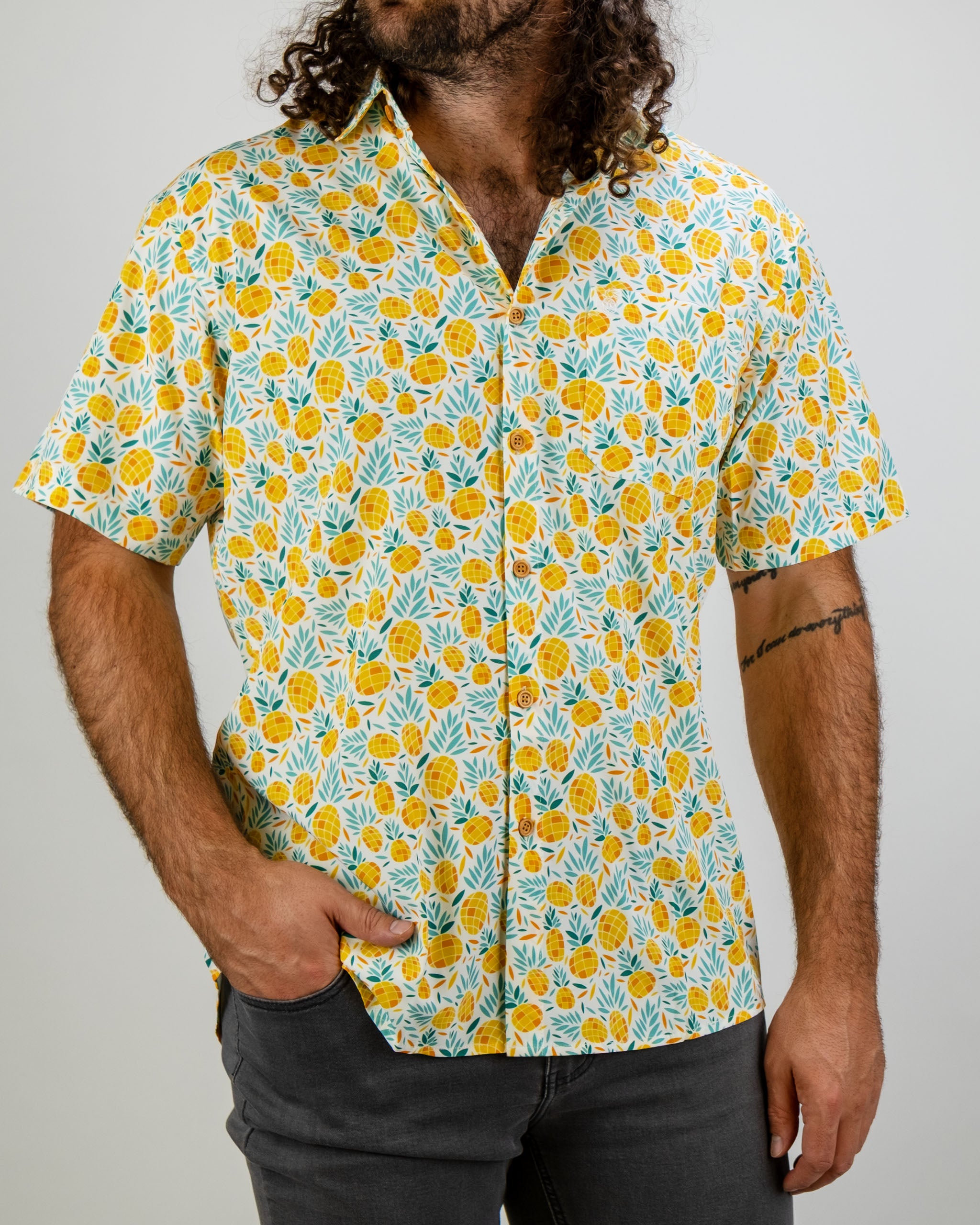 Colorful short-sleeve shirt featuring a vibrant pineapple and leaf pattern, perfect for a bold golf style.