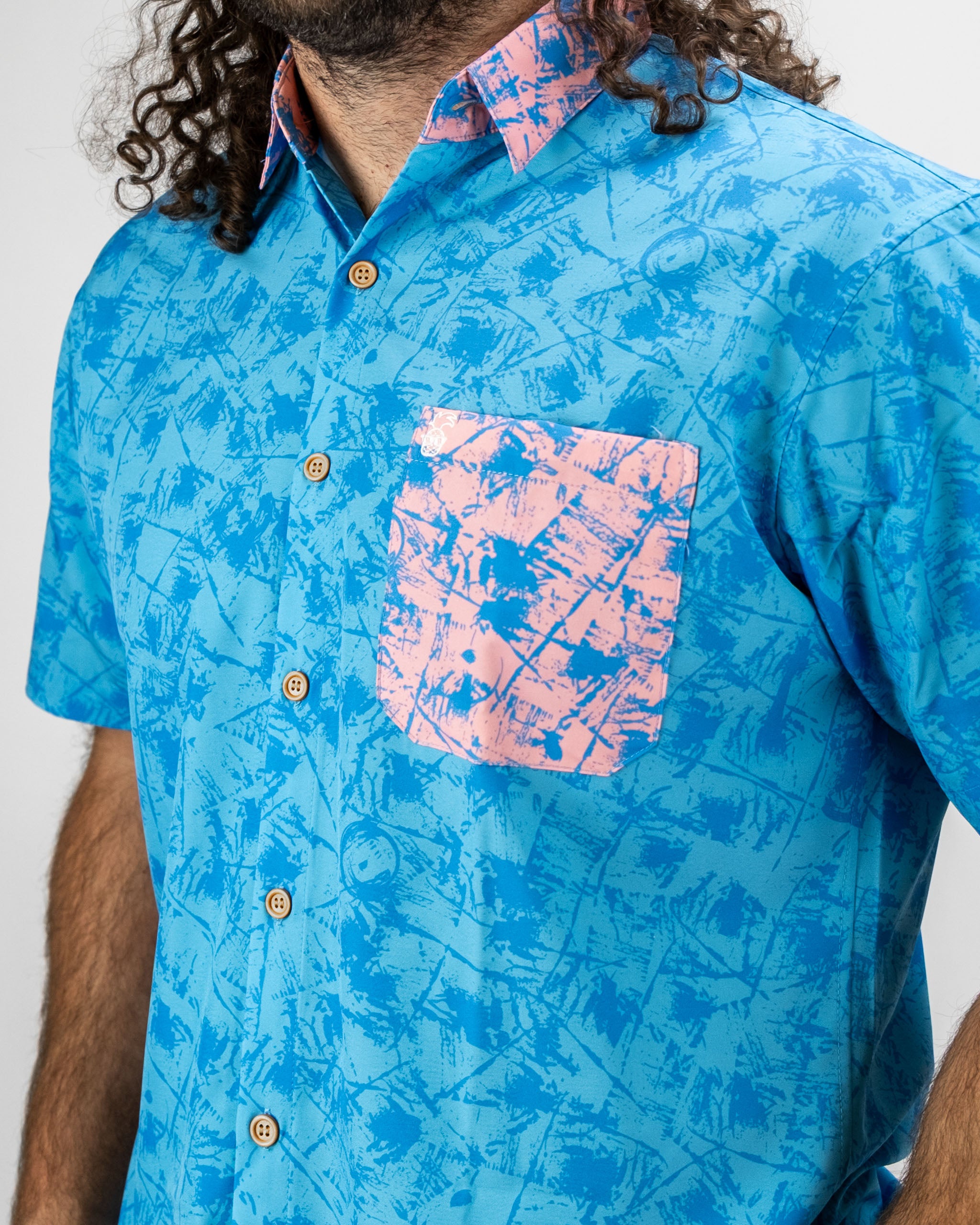 Men's blue short-sleeve shirt featuring a pink patterned pocket and collar, designed for a bold golf style.
