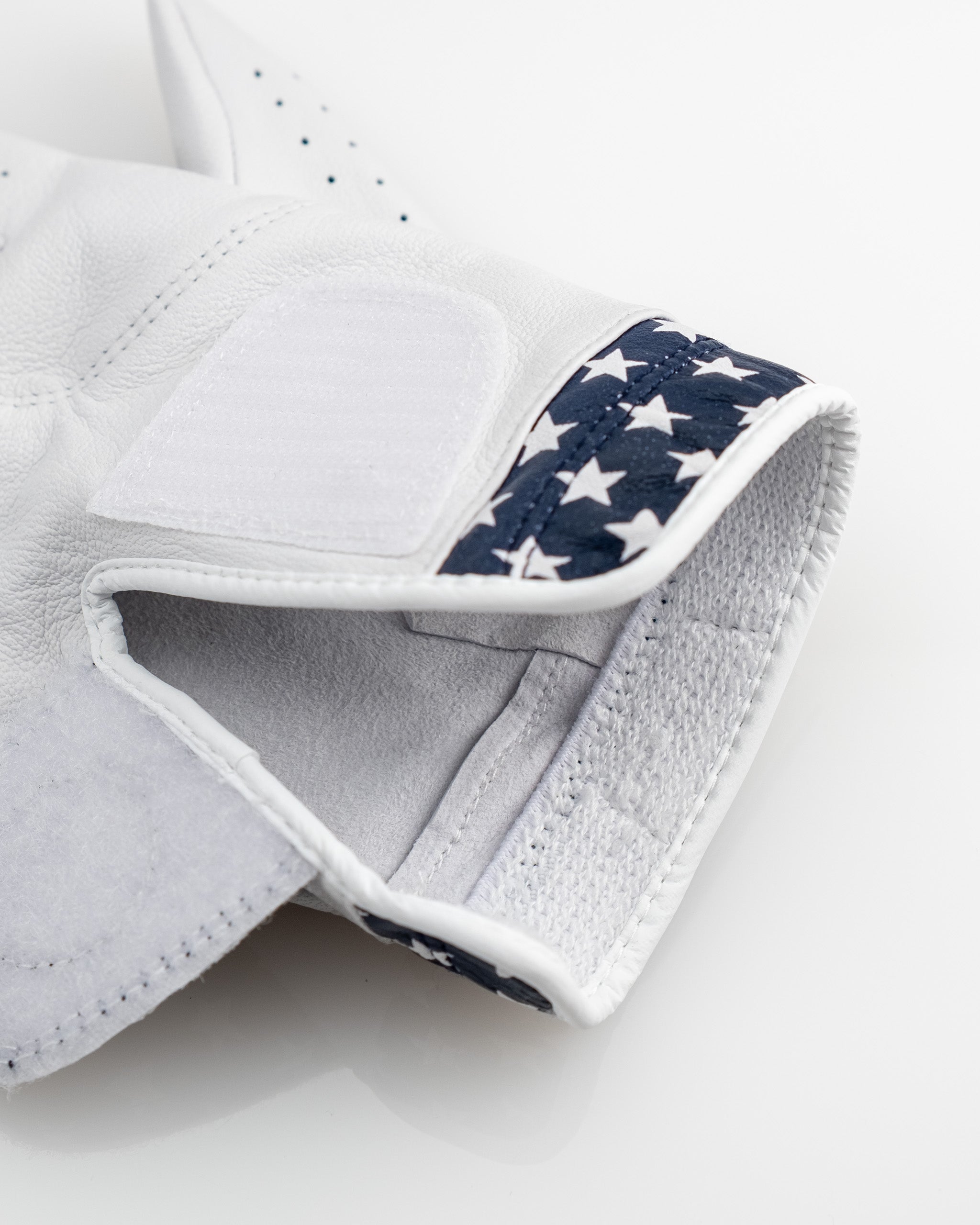 White golf glove with navy star-spangled cuff, featuring bold, unique golf apparel and accessories for standout players.