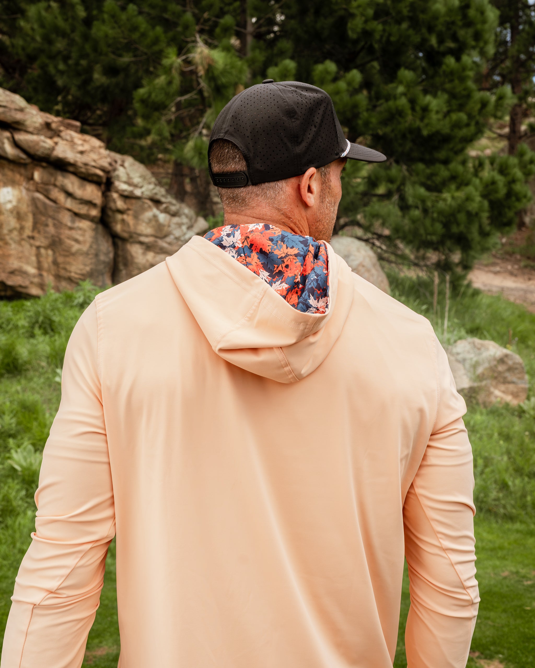 Men's performance golf hoodie in autumn leaves color, featuring a floral-patterned hood, perfect for stylish comfort on the course.