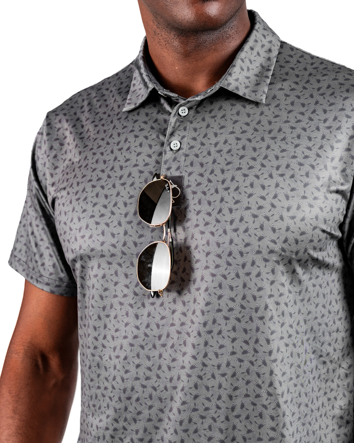 Men's Dry Fly golf polo shirt featuring a subtle pattern, with sunglasses casually hanging from the collar.