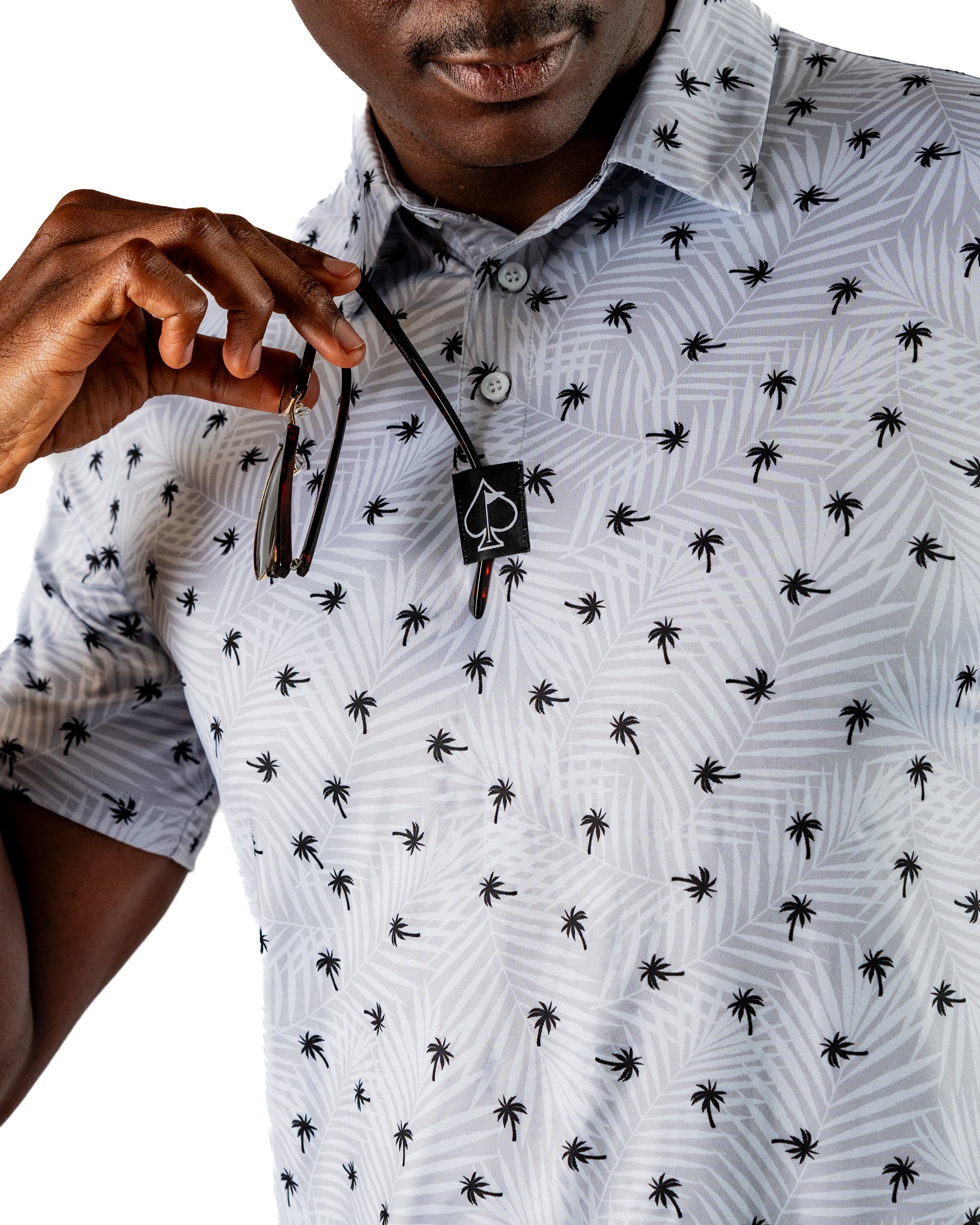 Men's golf shirt featuring a palm tree pattern in gray and black, designed for a stylish and bold look on the course.