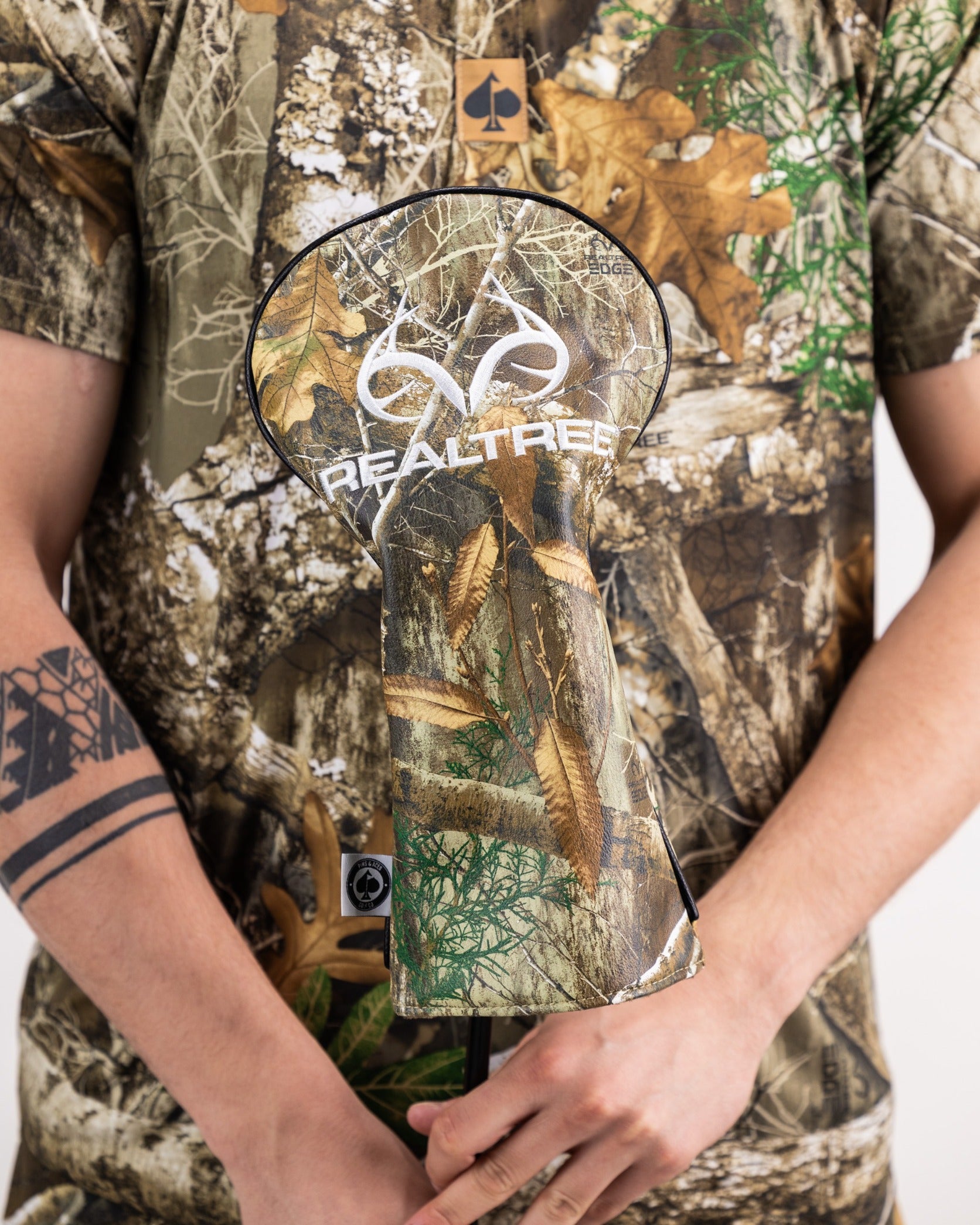 Realtree Edge Polo featuring a camouflage design, paired with a matching golf headcover, ideal for outdoor enthusiasts.
