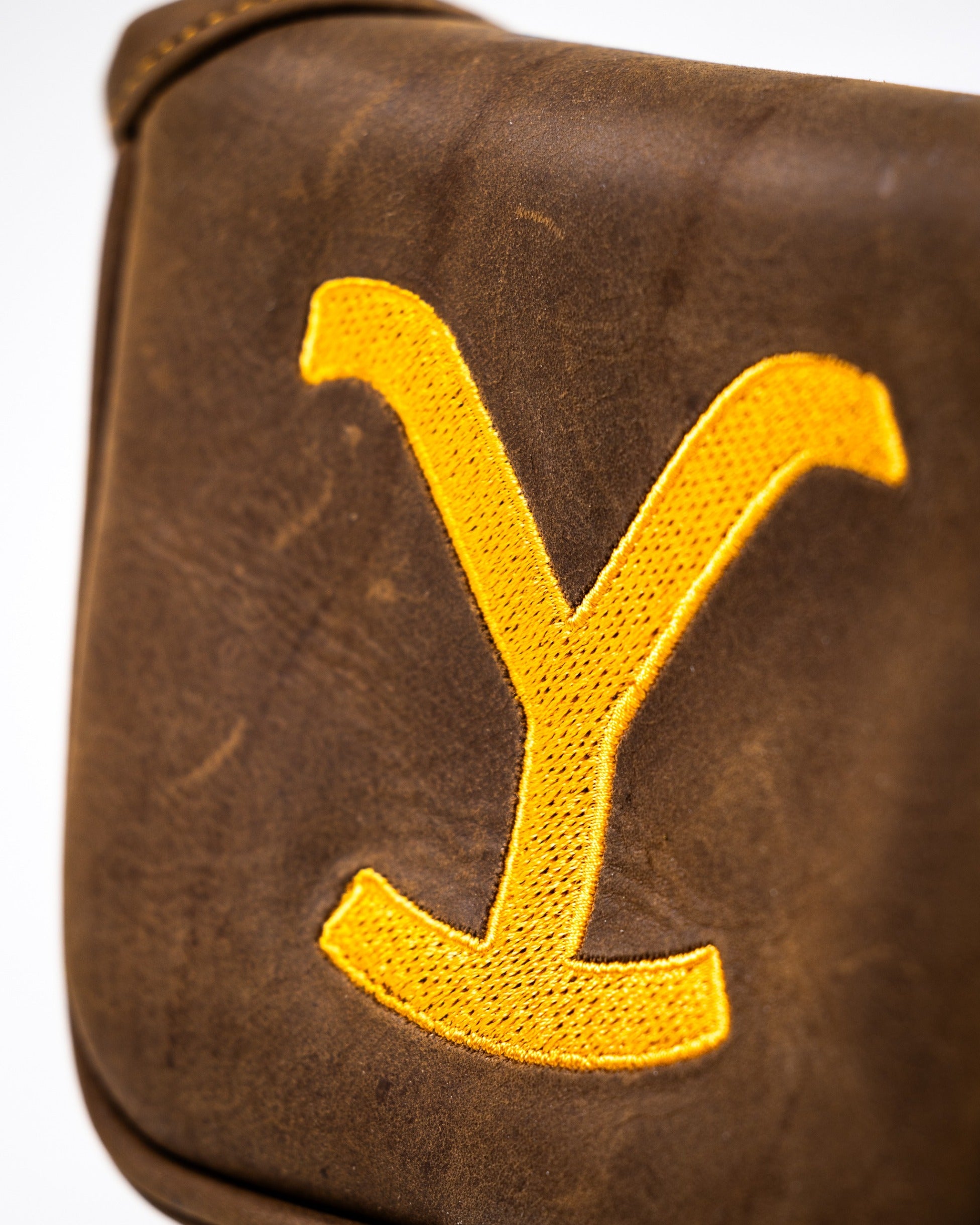 Yellowstone mallet putter cover featuring a bold yellow "Y" logo on a rich brown leather background.