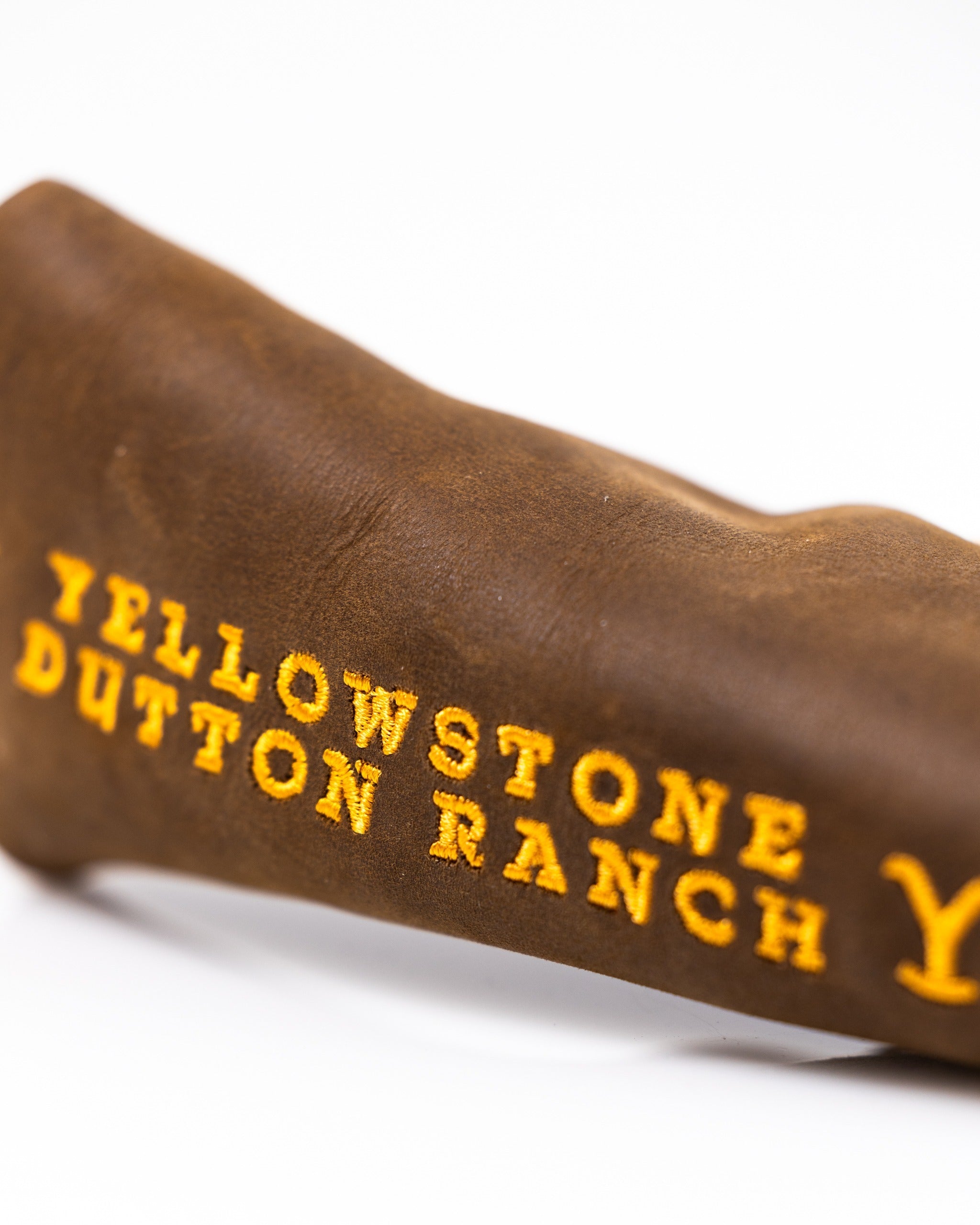 Yellowstone Putter Cover in brown leather featuring bold yellow "Yellowstone Dutton Ranch" embroidery.