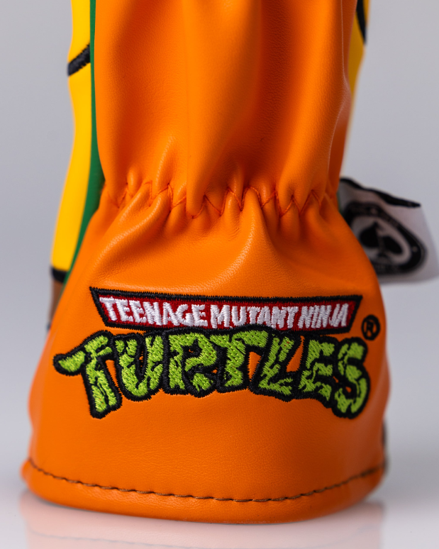 Michelangelo hybrid golf headcover featuring vibrant orange and green colors with Teenage Mutant Ninja Turtles branding.