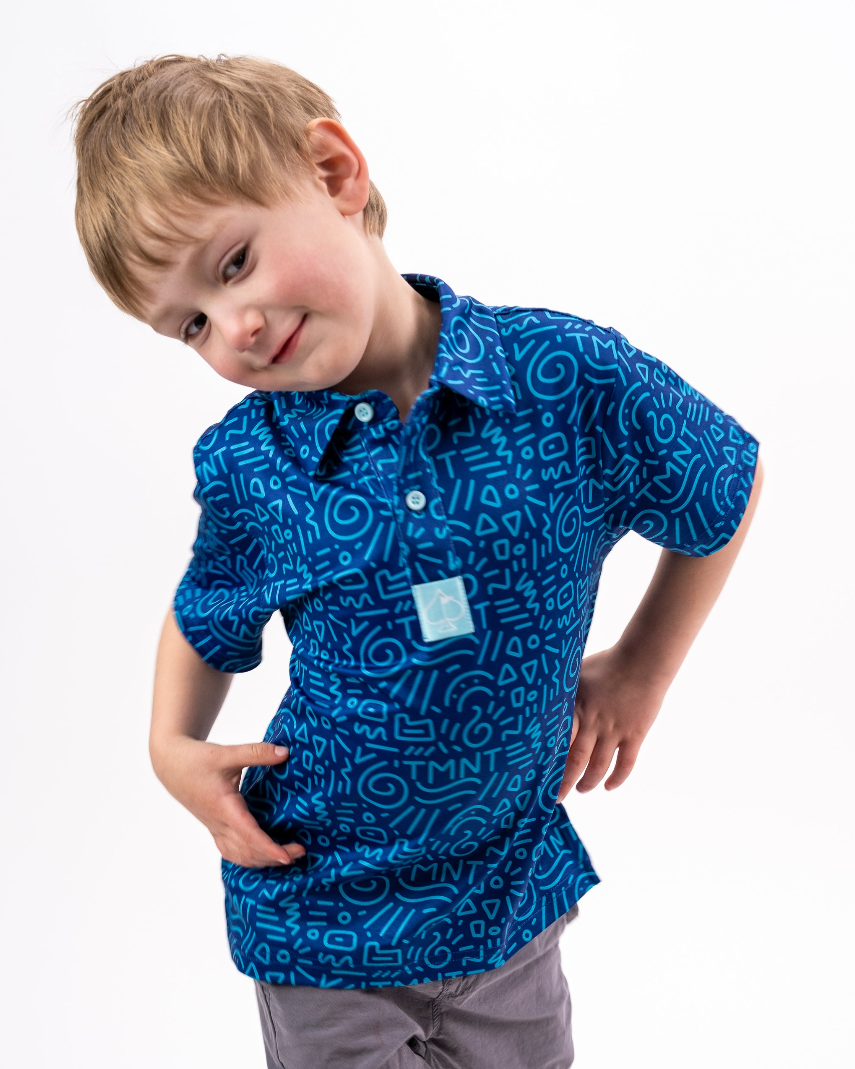 Youth wearing a blue TMNT polo shirt featuring a doodle pattern, posing playfully with a smile.