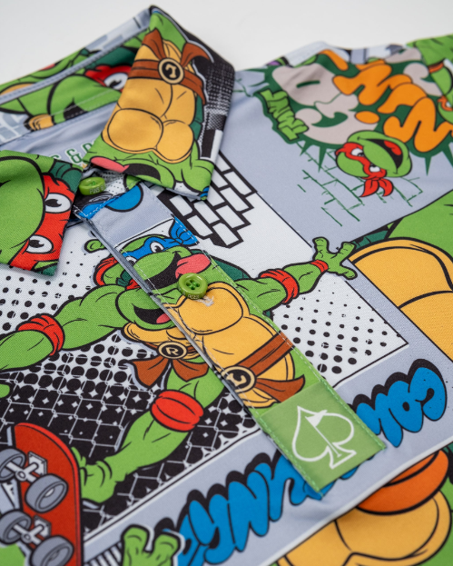 Youth shirt featuring vibrant Teenage Mutant Ninja Turtles comic strip design with colorful graphics and playful characters.