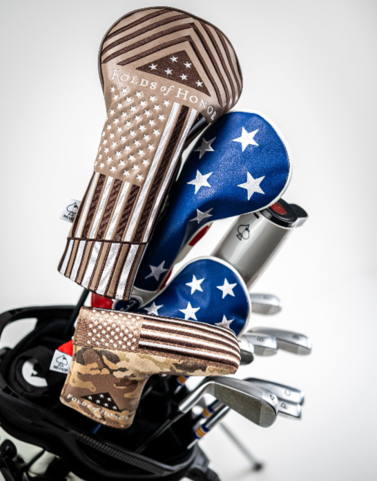 Folds of Honor 2.0 driver cover featuring a patriotic design with stars and stripes, displayed on a golf bag with clubs.