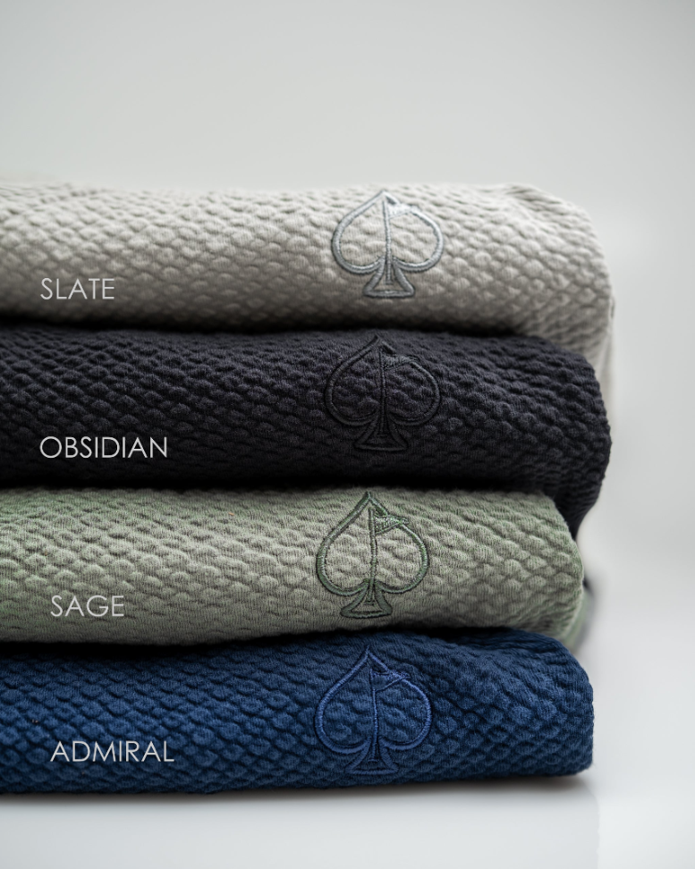 Waffleknit shorts in Admiral, Slate, Obsidian, and Sage colors, featuring a spade logo on each. Ideal for stylish golfers.
