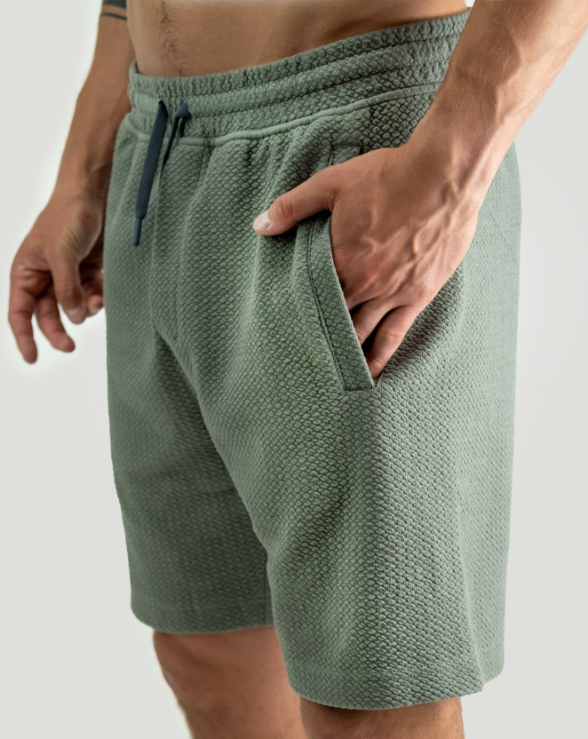 Men's sage green waffle knit shorts featuring a comfortable fit and side pockets, perfect for casual wear or golf outings.