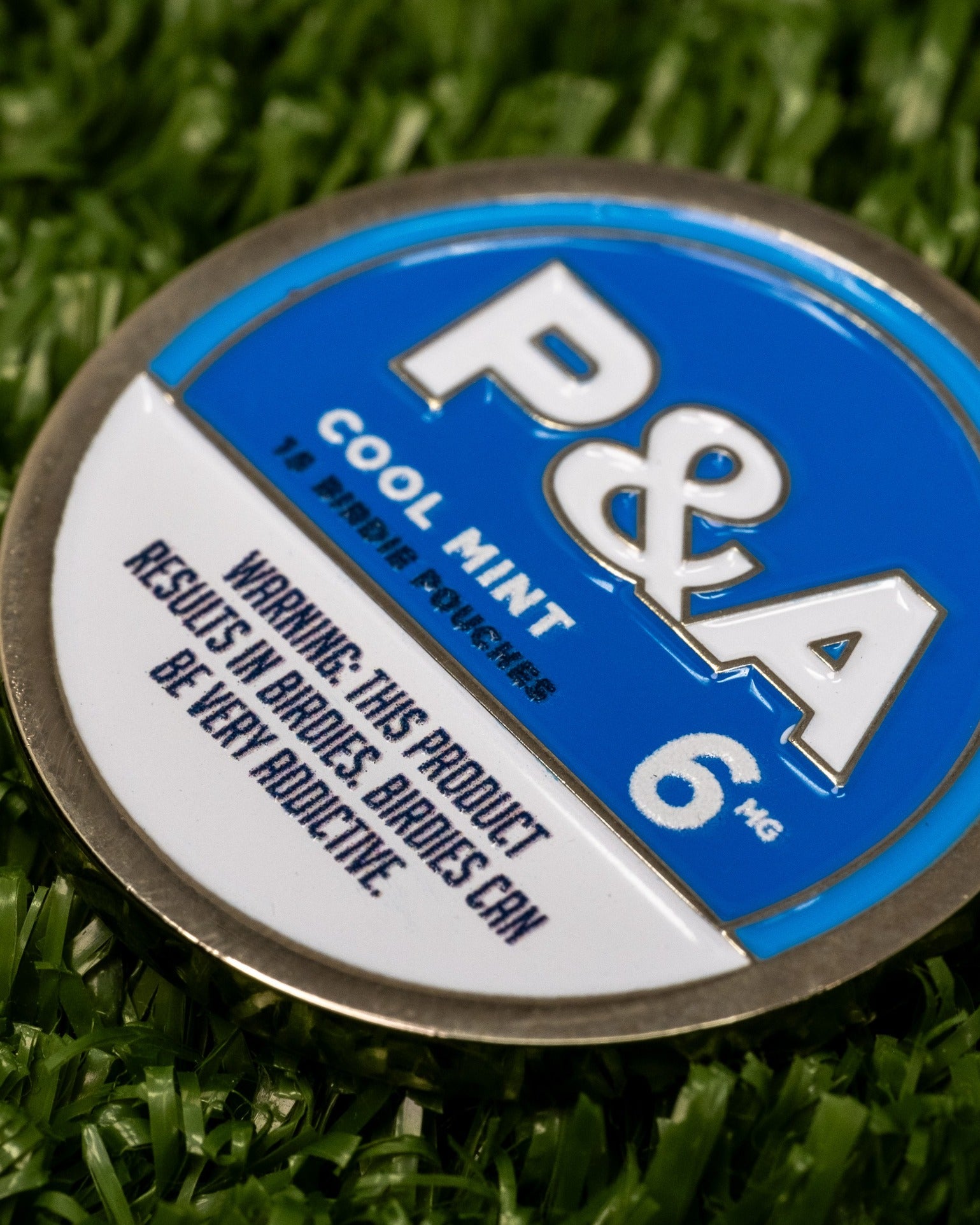 Cool Mint ball marker featuring a blue and silver design, highlighting its branding and warning about addictive qualities.