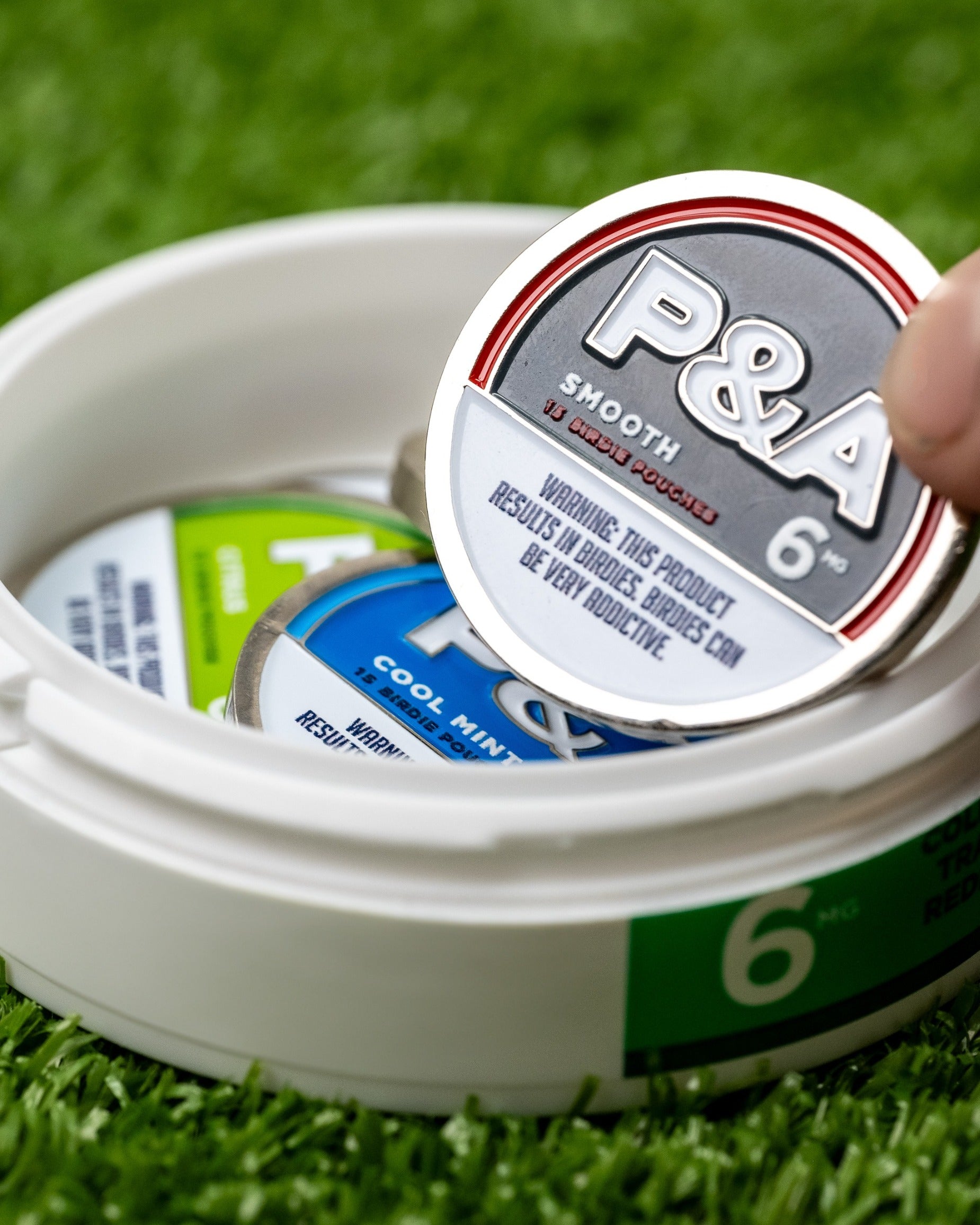 Smooth ball marker from Pins and Aces, featuring a sleek design and bold branding, ideal for stylish golfers.