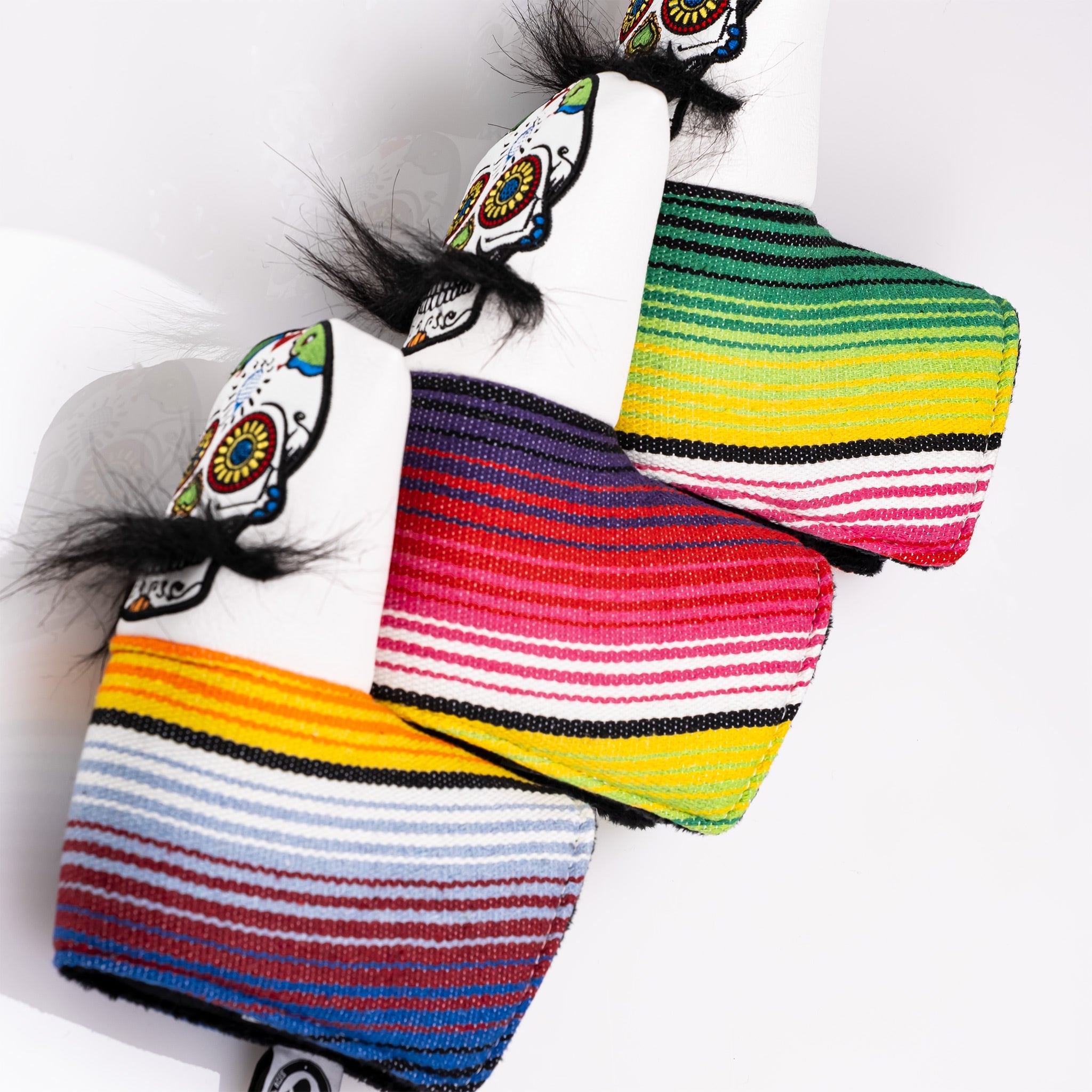 Bold white putter cover featuring a mustache sugar skull design with colorful striped accents and playful black hair.