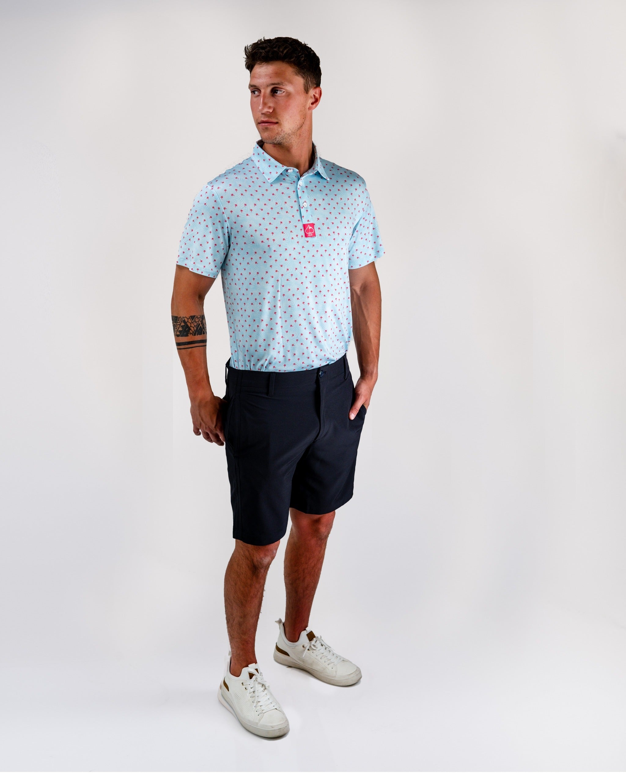 Men's black performance shorts paired with a light blue polka dot polo, ideal for stylish golf outings.