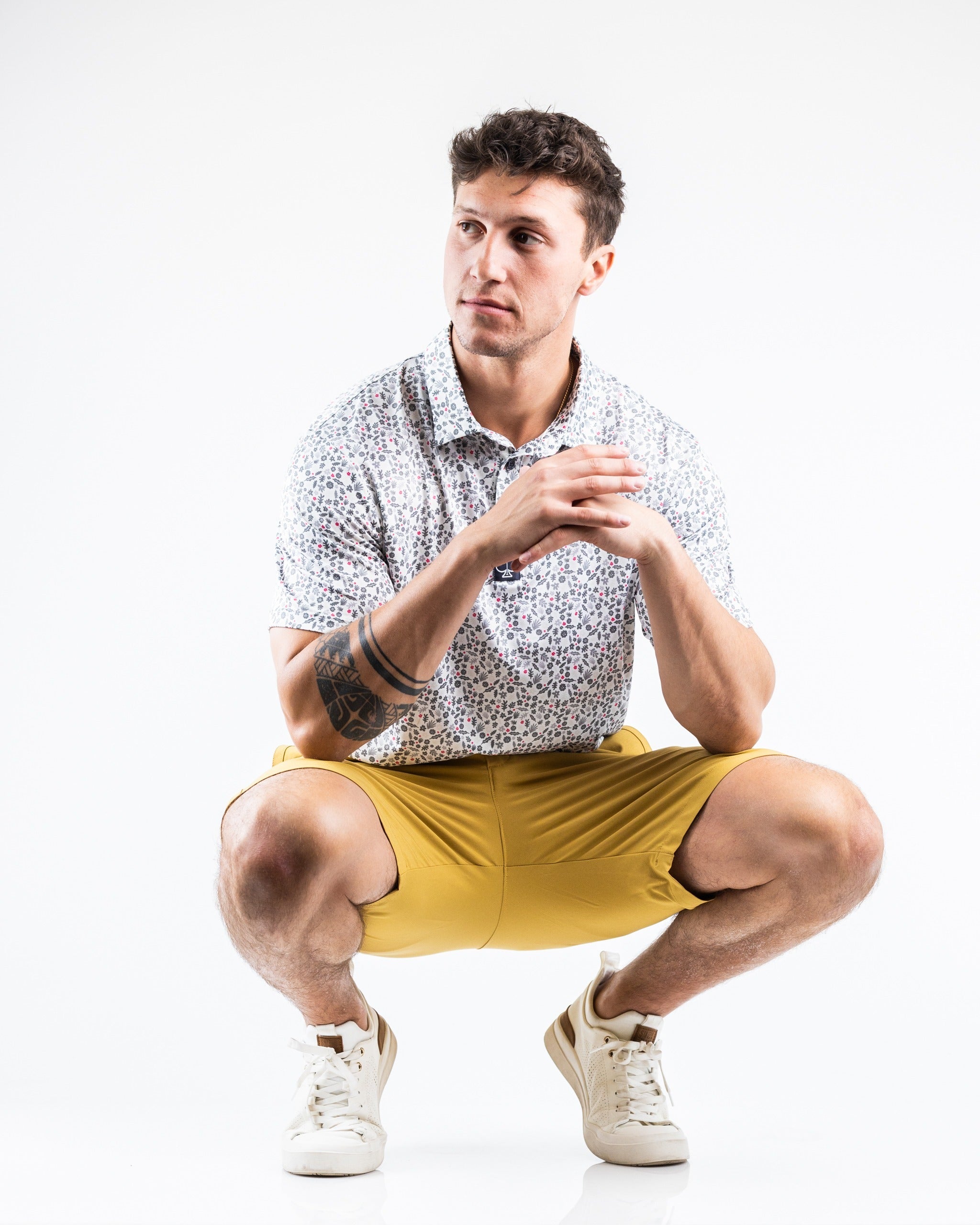Men's performance shorts in dune color, paired with a patterned shirt, ideal for stylish comfort on the golf course.