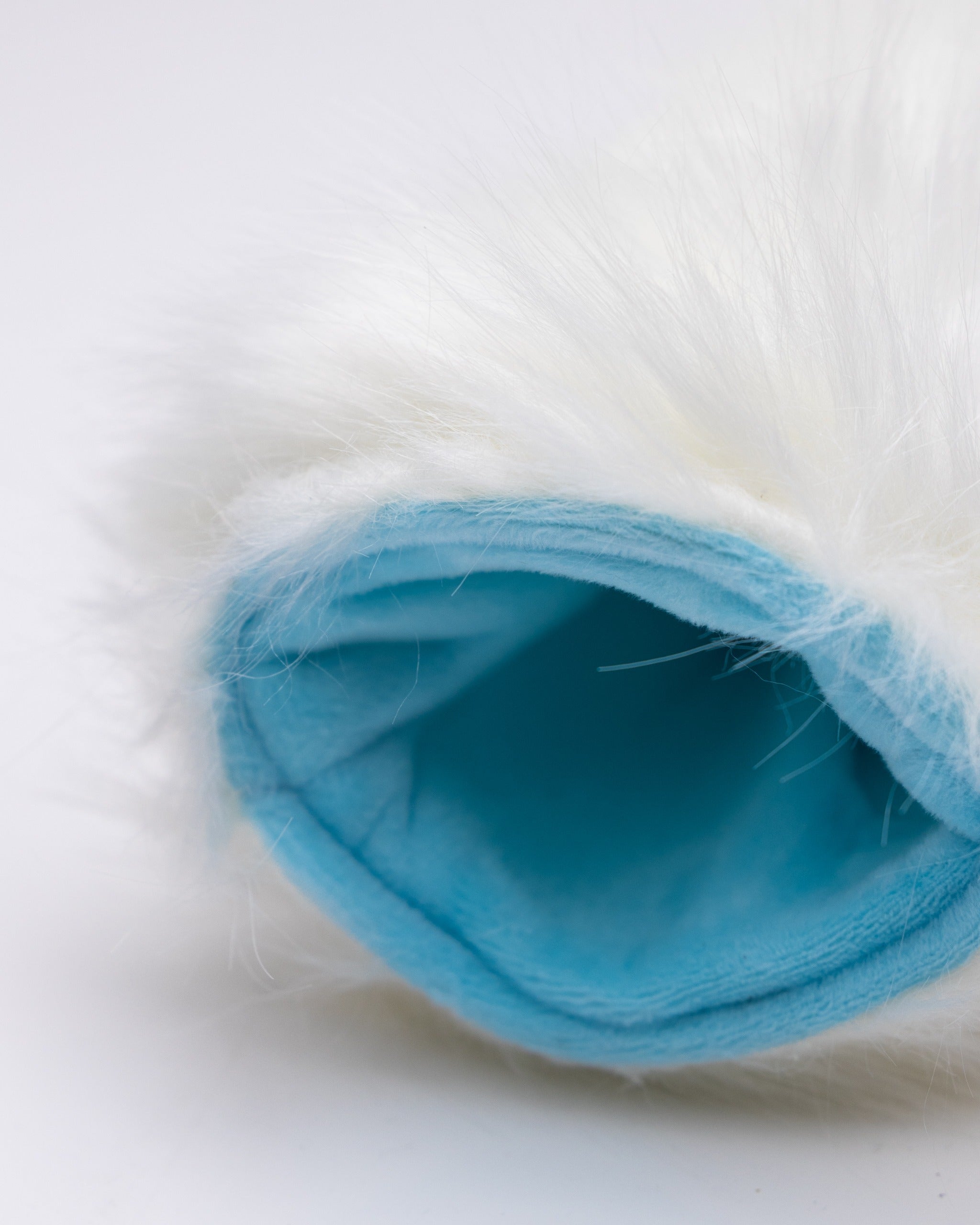 Soft, white fur fairway cover with a light blue interior, designed to protect golf clubs with style.
