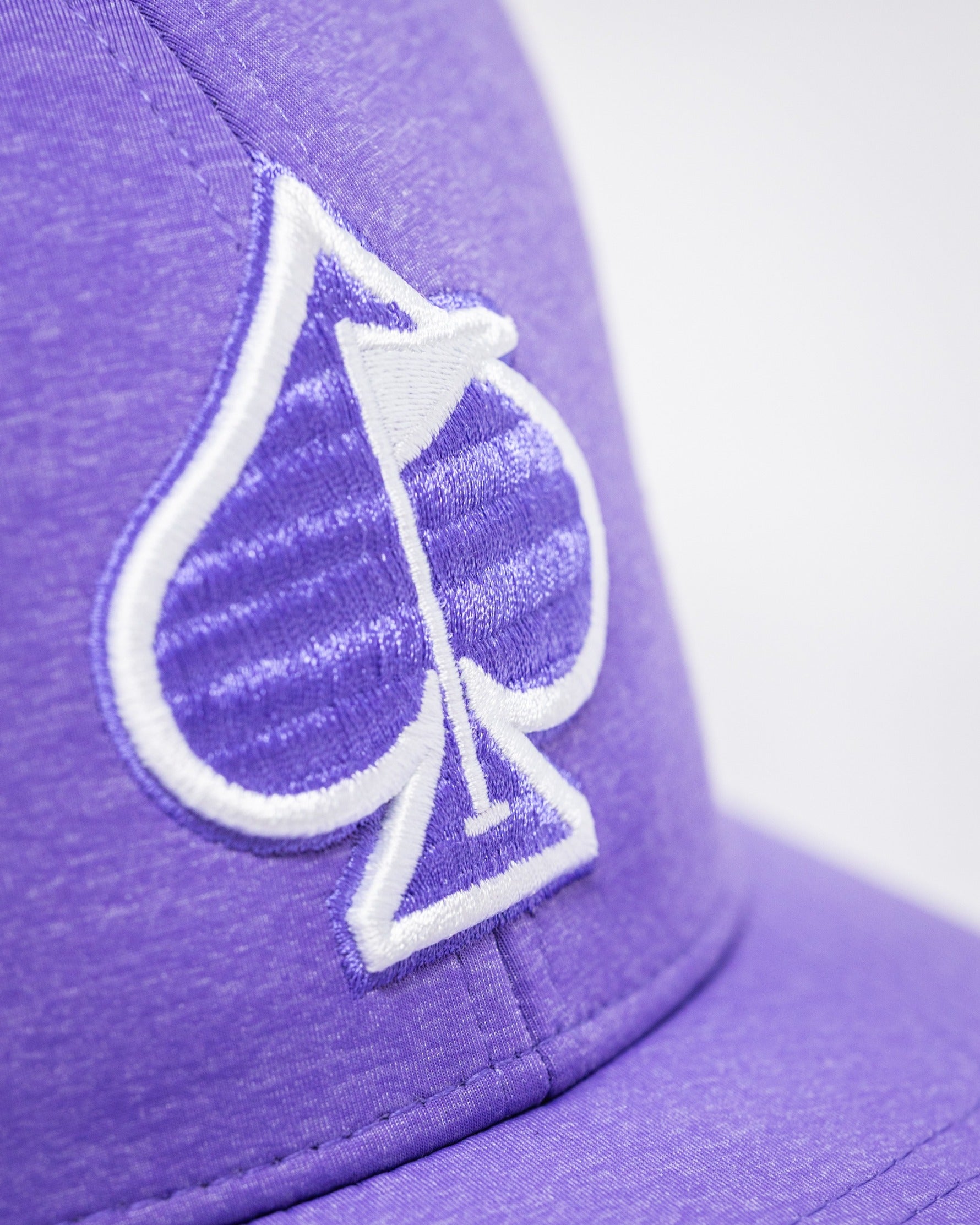 Lavender Performance Spade Hat featuring a white spade logo, designed for stylish golfers seeking standout apparel.