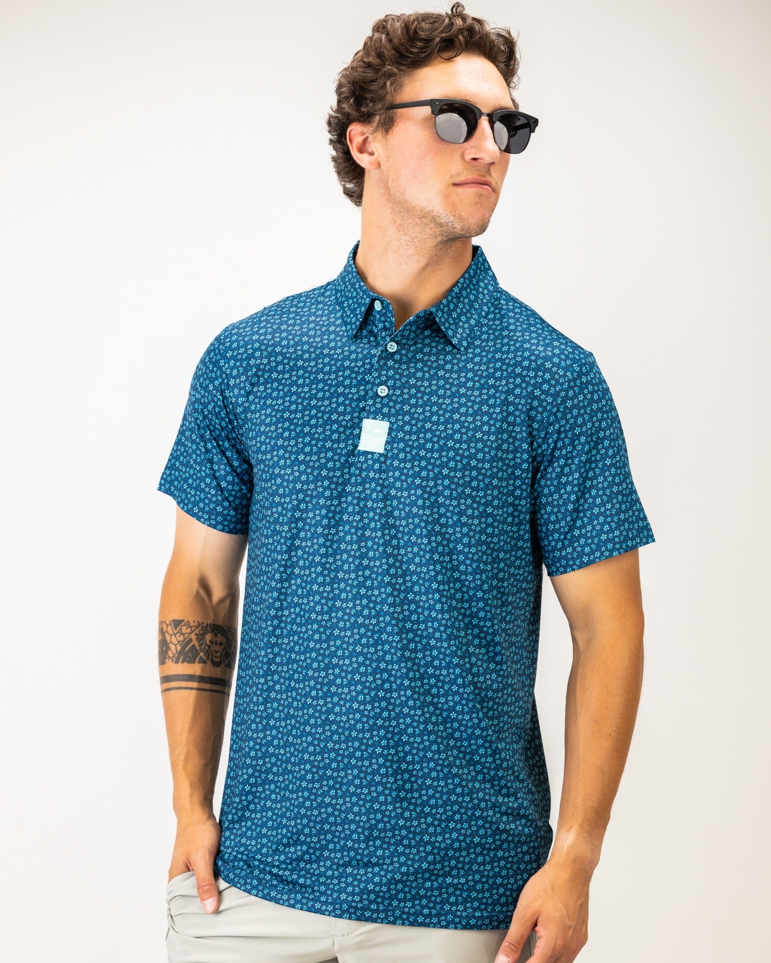 Men's blue polo shirt featuring a micro floral pattern, perfect for stylish golf outings and casual wear.