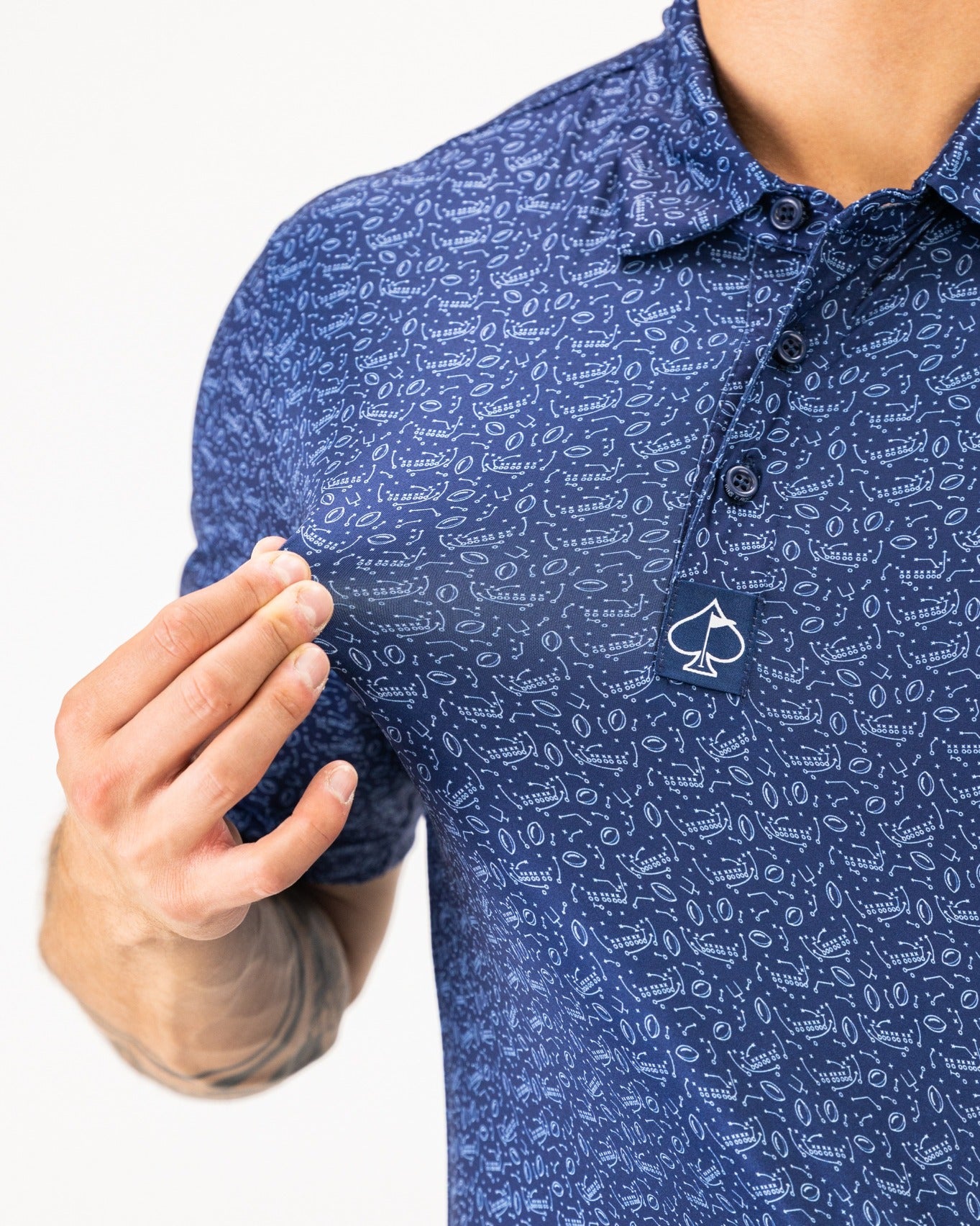 Navy blue golf polo shirt featuring a playful pattern and a spade logo on the collar, designed for stylish golfers.
