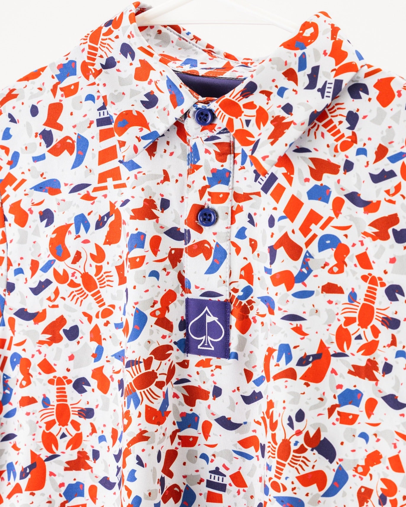 Youth Lobster Shatter golf shirt featuring a vibrant lobster and nautical-themed pattern in red, blue, and white.