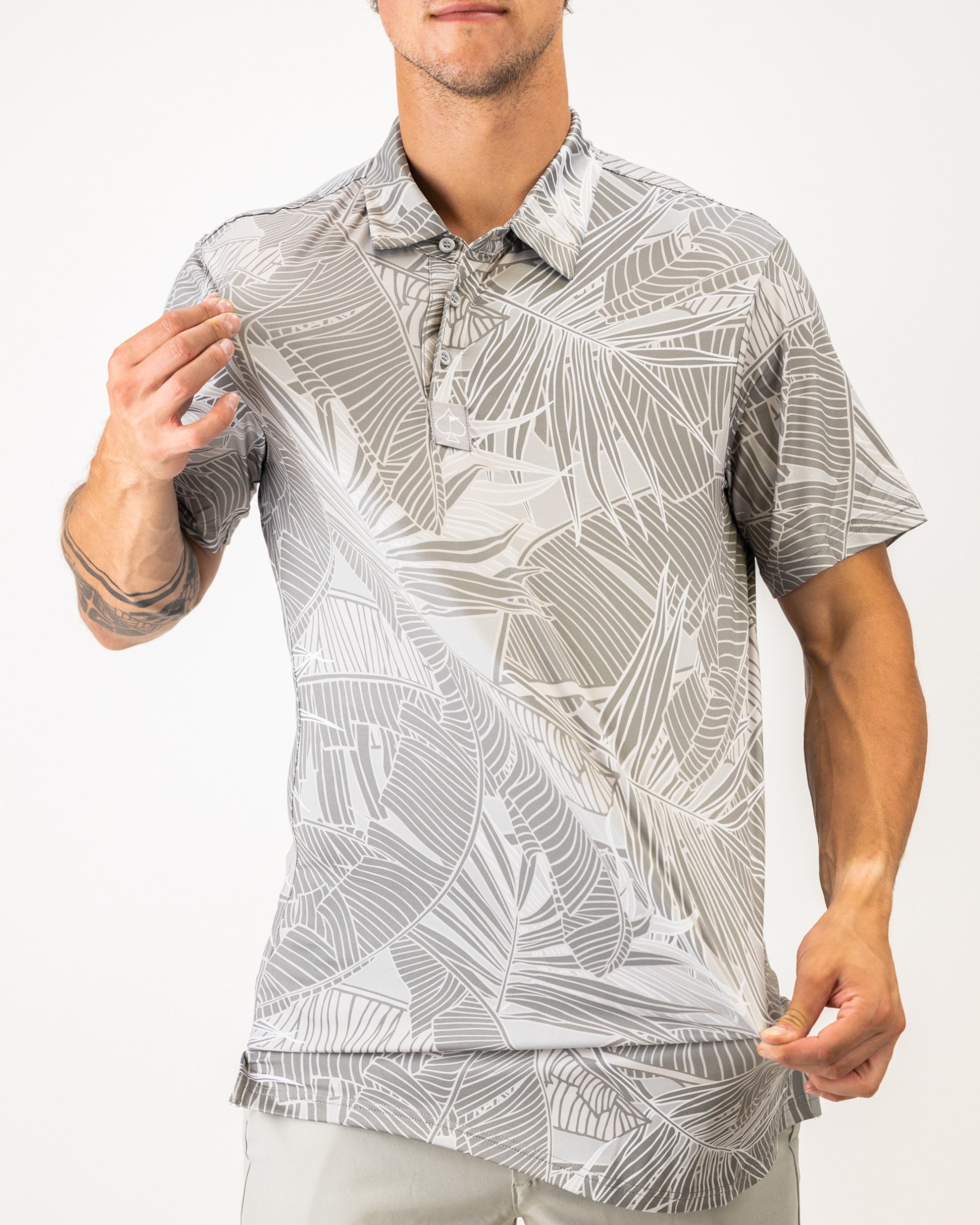 Men's golf polo featuring a stylish palm leaf pattern in shades of gray, designed for a bold look on the course.