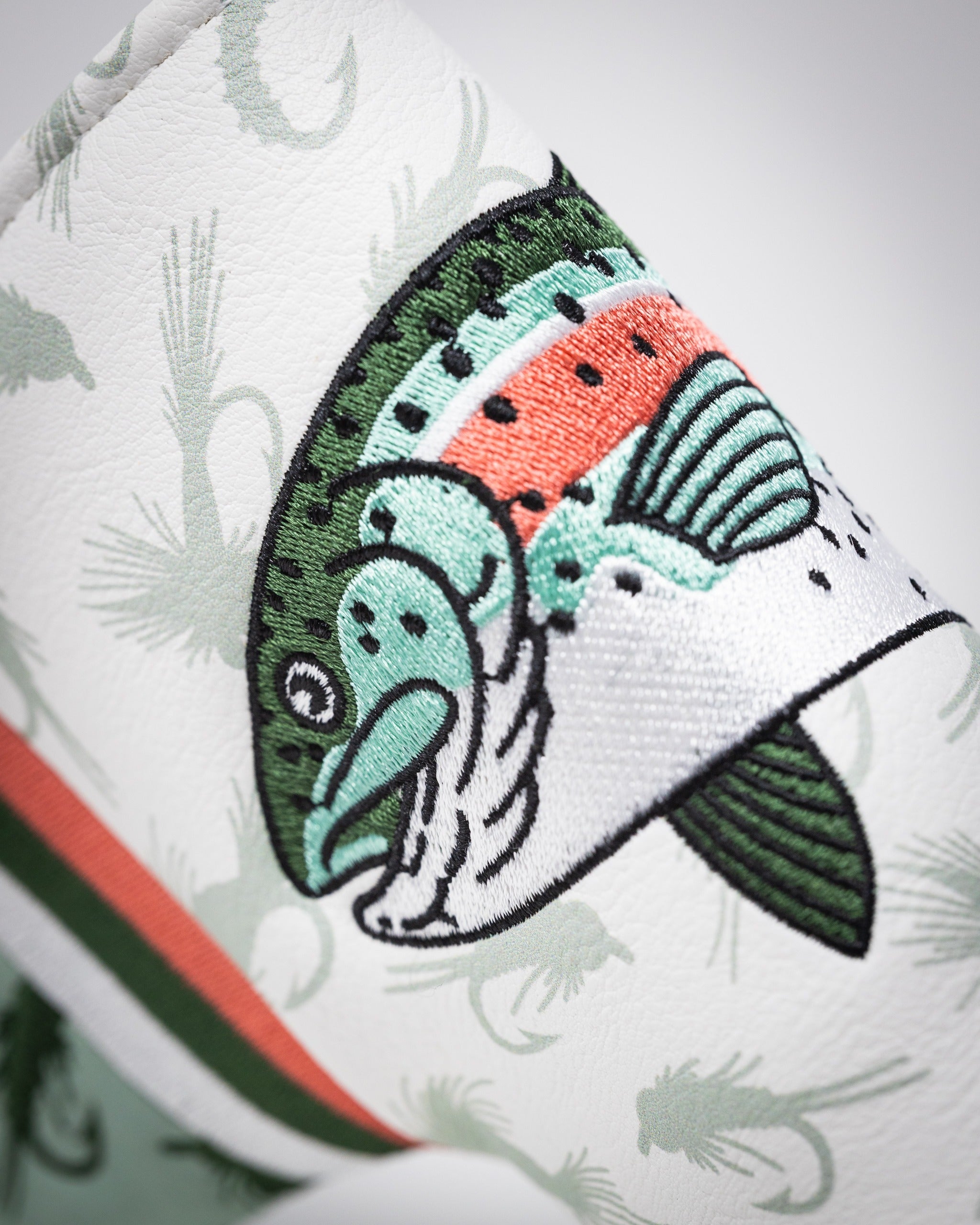 Trout Blade Putter Cover featuring vibrant embroidery of a fish design on a textured white background.