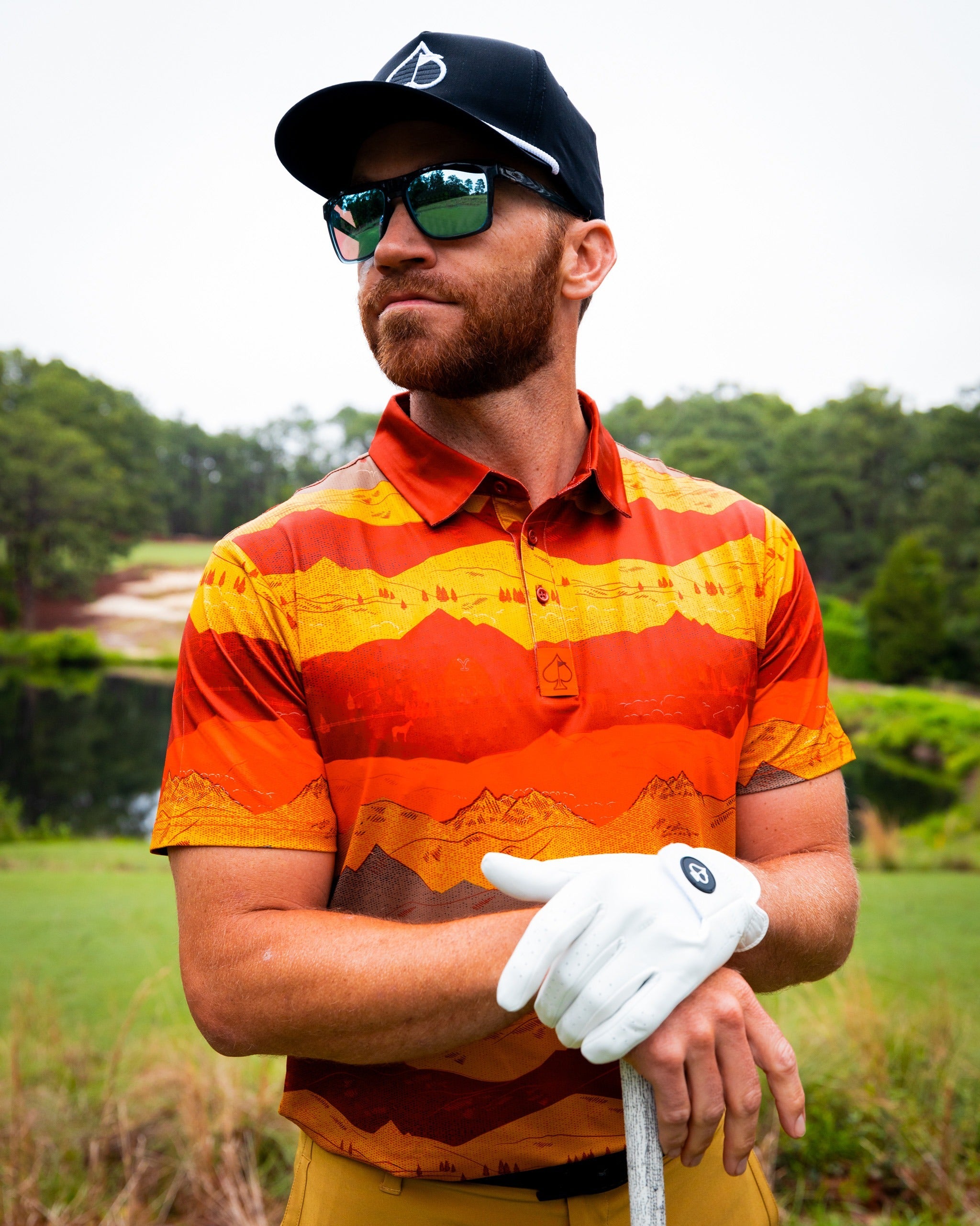 Bold golf polo featuring a vibrant Yellowstone Montana sunset design in warm hues, perfect for stylish golfers on the course.
