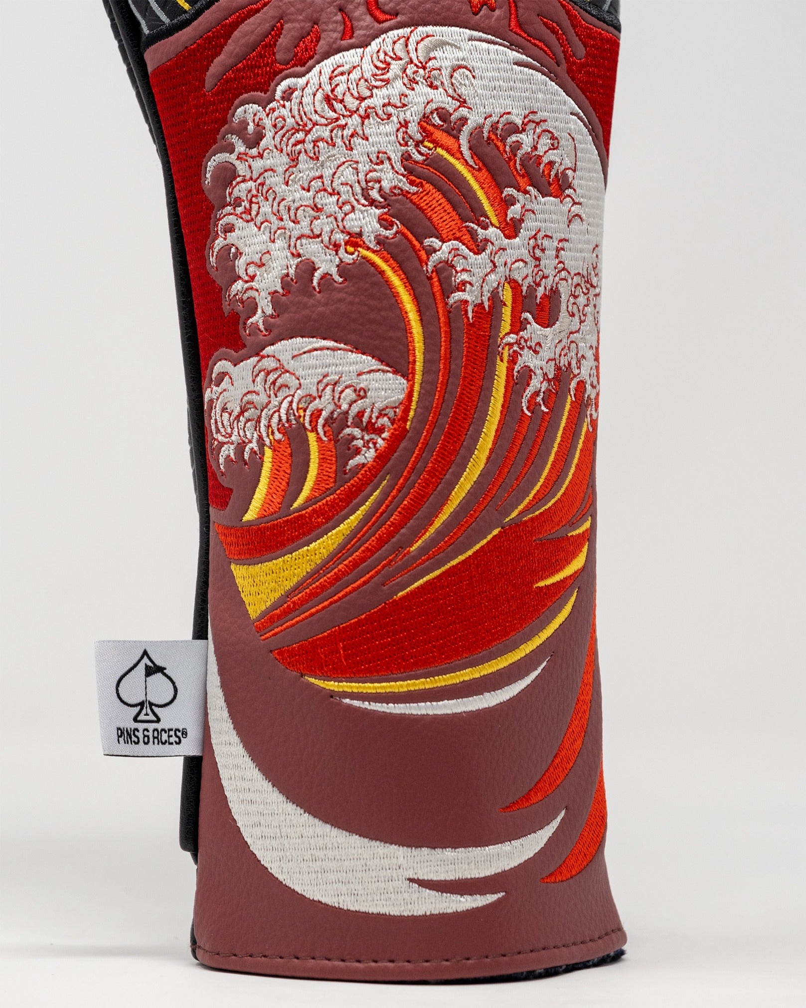 Bold fairway cover featuring a vibrant red and orange wave design with intricate embroidery, perfect for standout golfers.