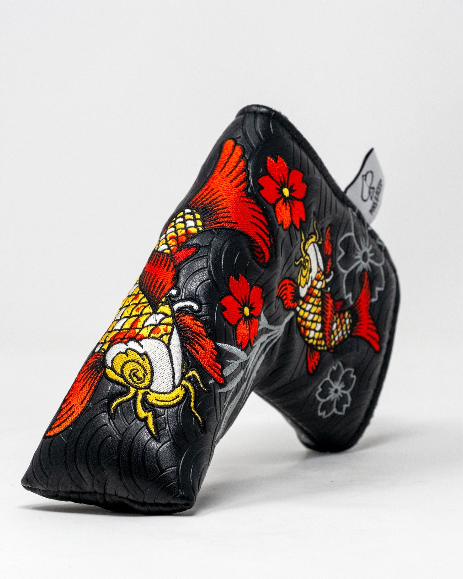 Koi Flow Blade Putter Cover featuring vibrant koi fish and floral designs on a textured black background.