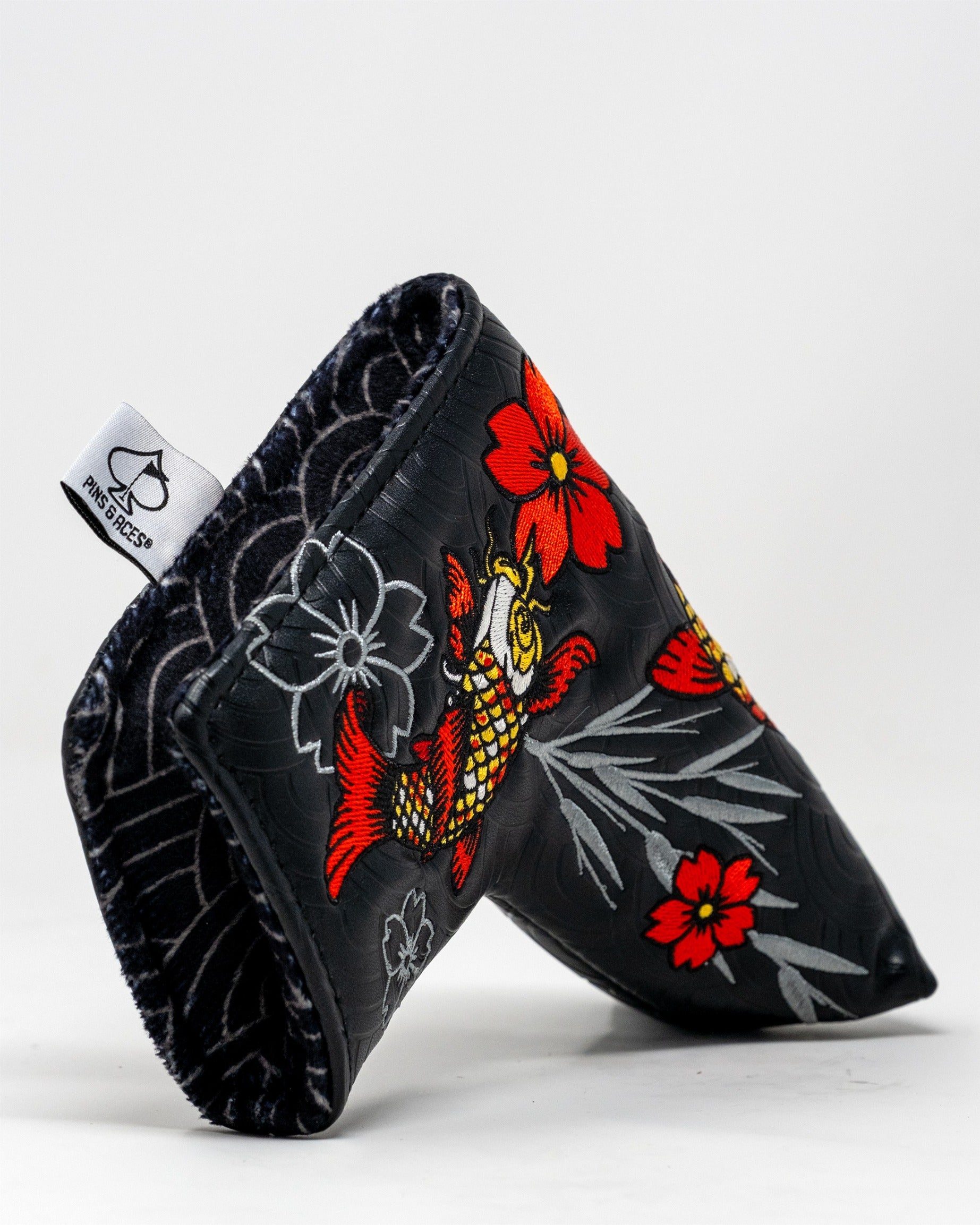 Koi Flow blade putter cover featuring vibrant koi fish and floral designs on a black background for stylish golf protection.